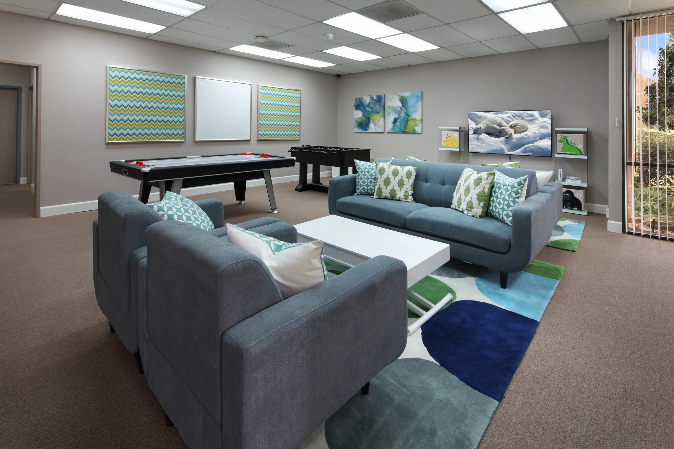 Child therapy room with game table, lounge seating, and colorful rug
