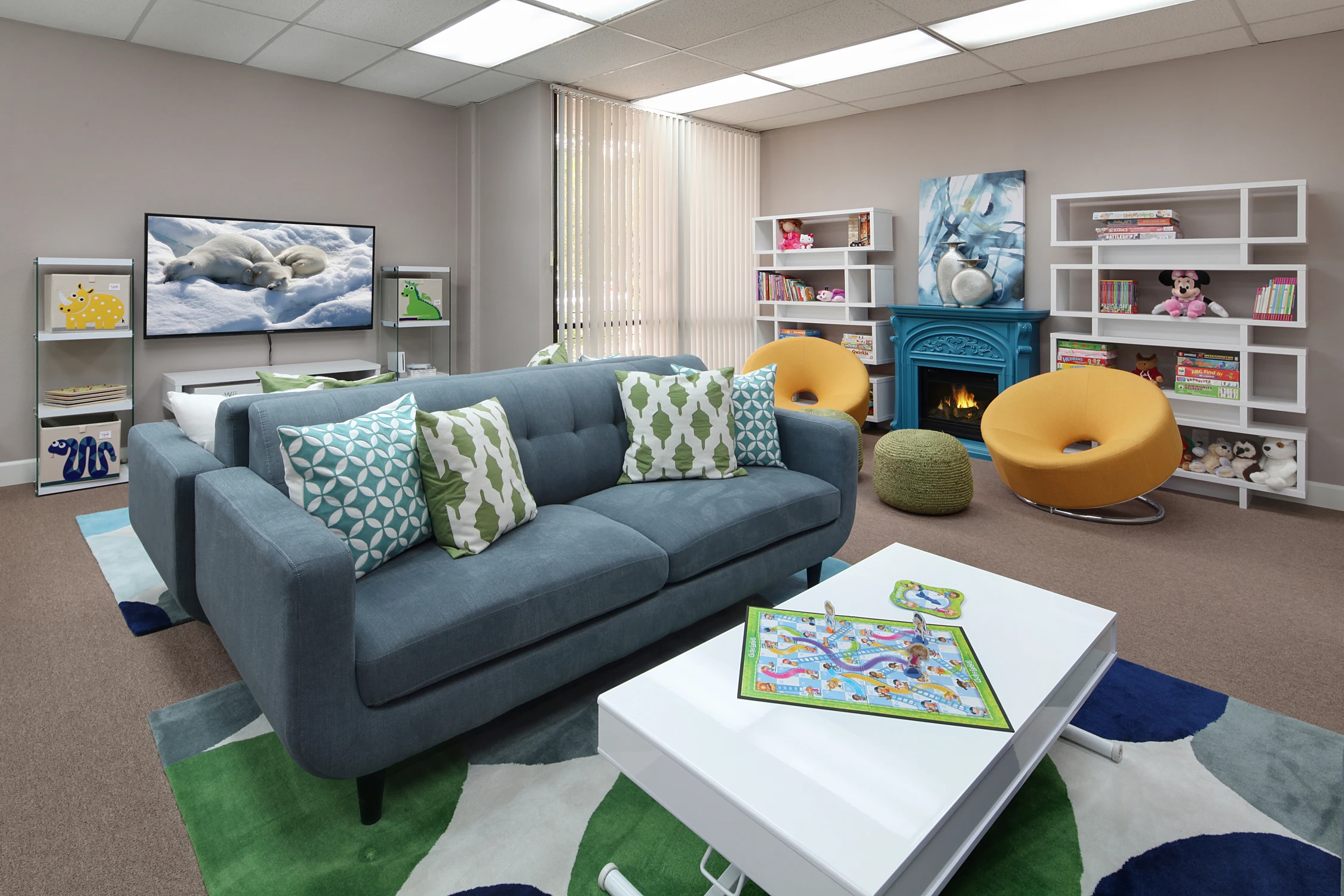 Blue sofa and bright rug in child therapy room