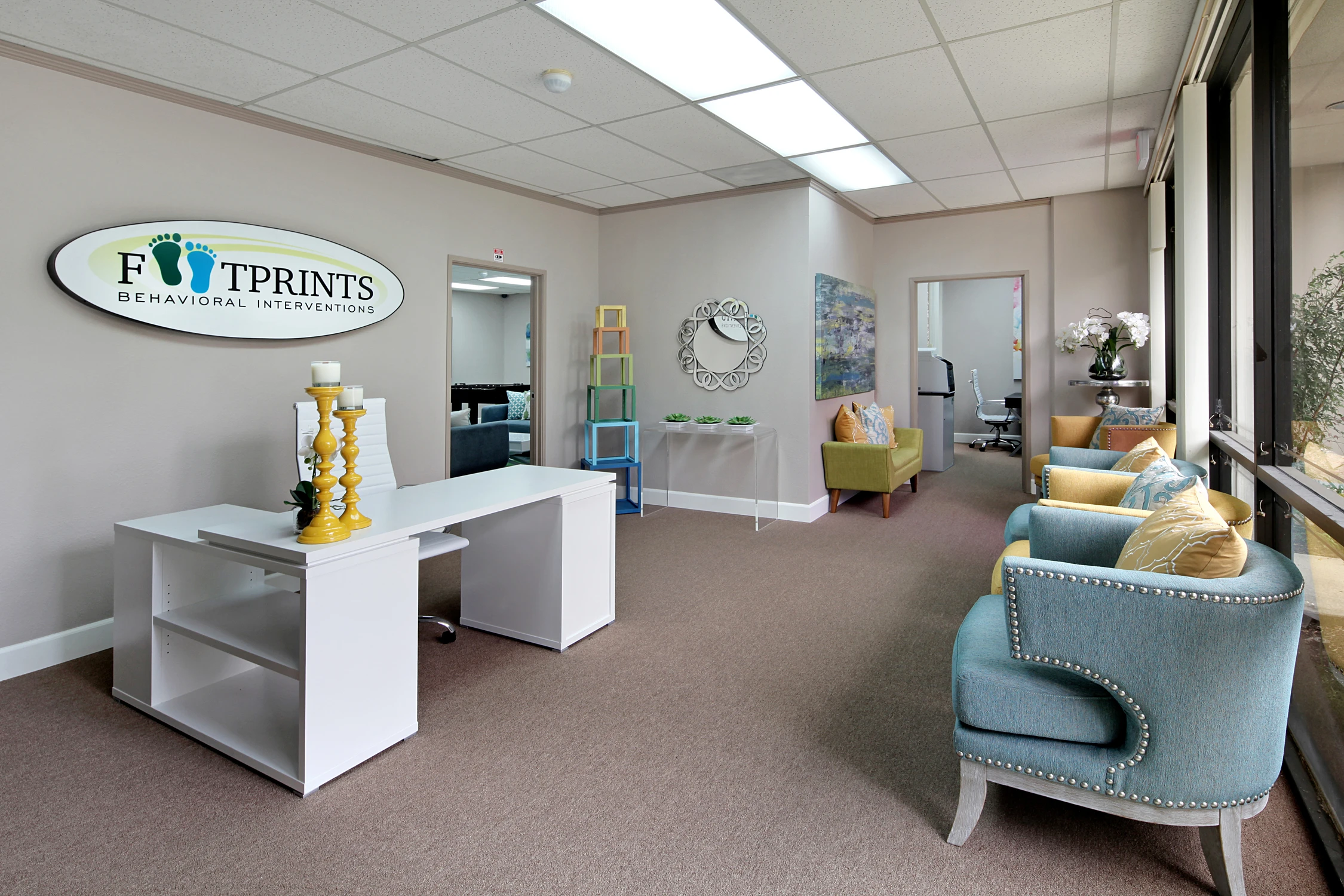 Behavioral clinic reception with white desk and turquoise seating