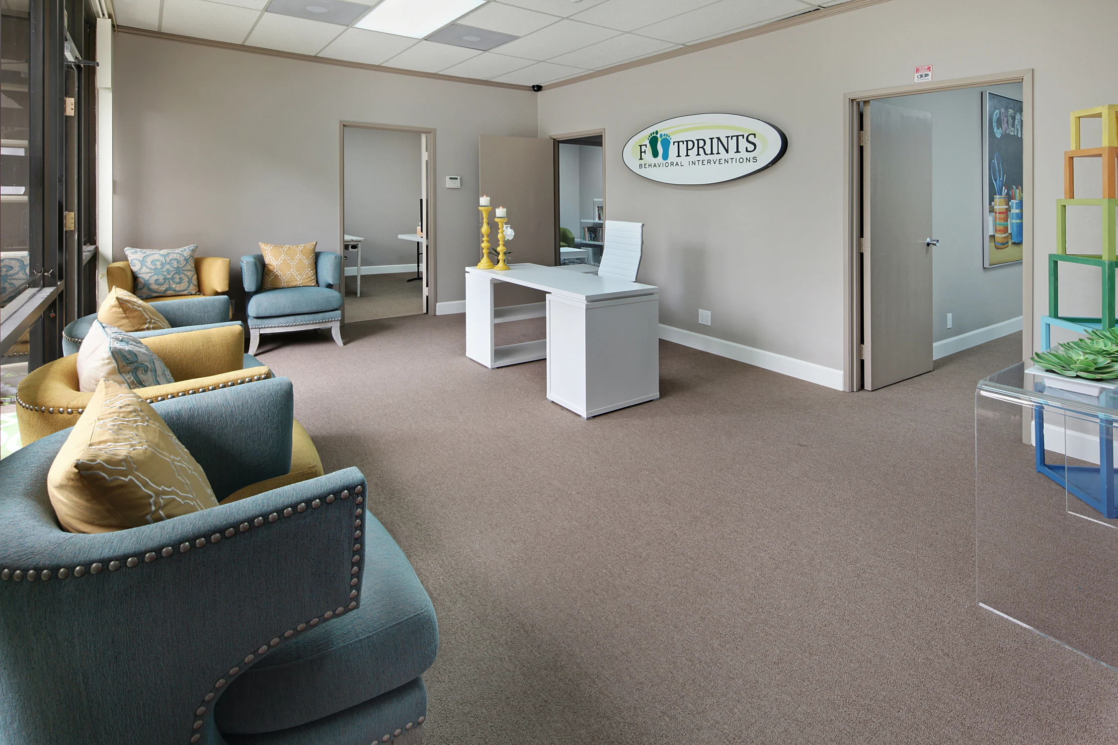 Reception lounge with blue armchairs and bright display shelving