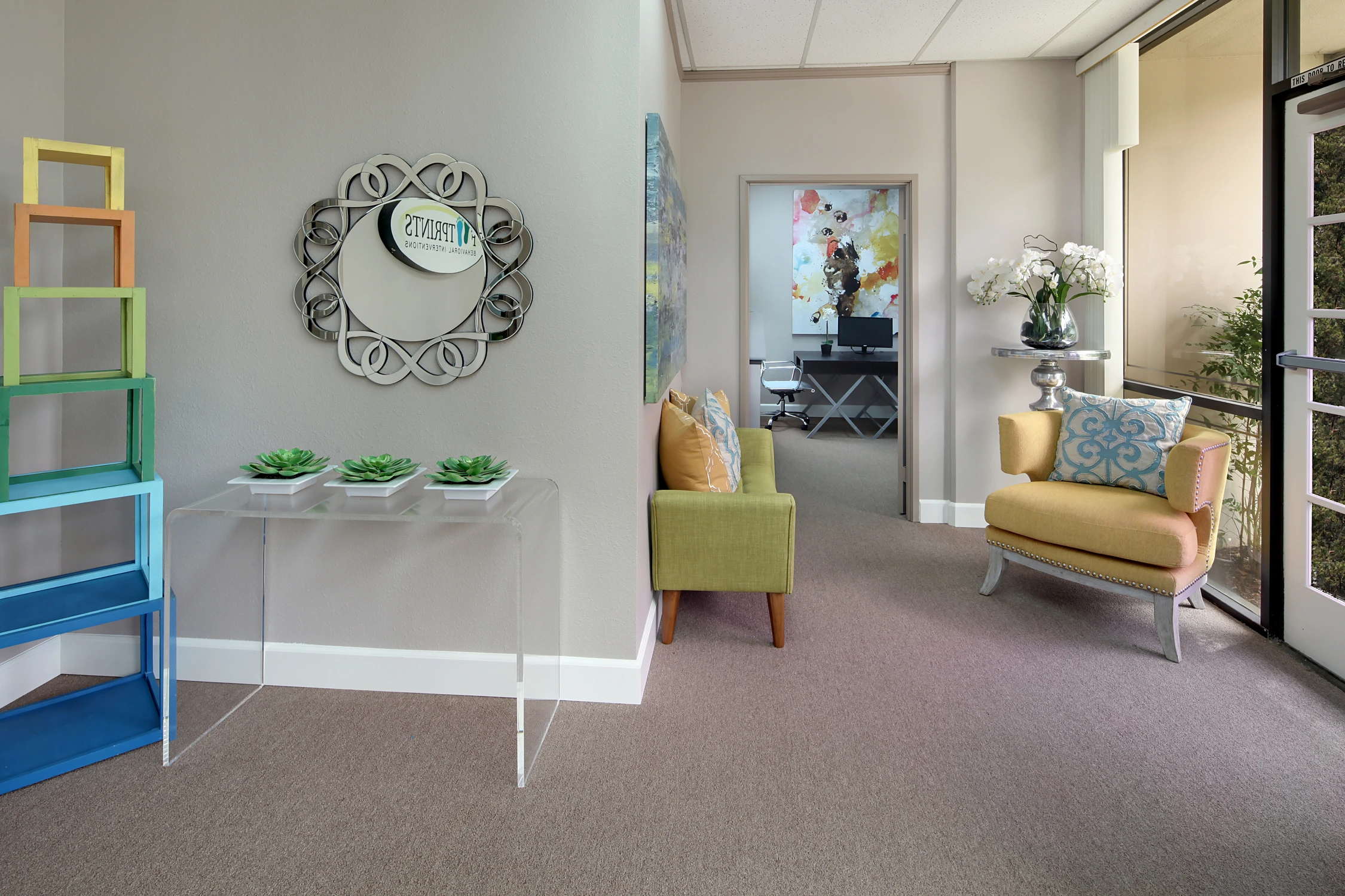 Reception counter beside lime green chairs and colorful storage shelf