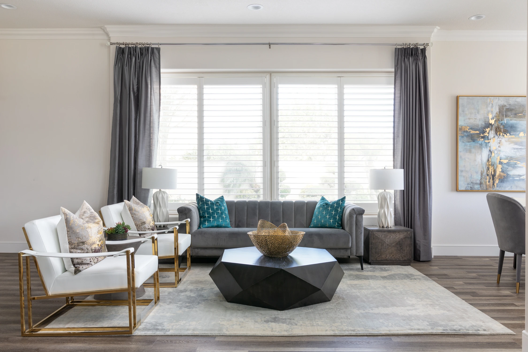 Gray sofa and white armchairs in a bright formal sitting room