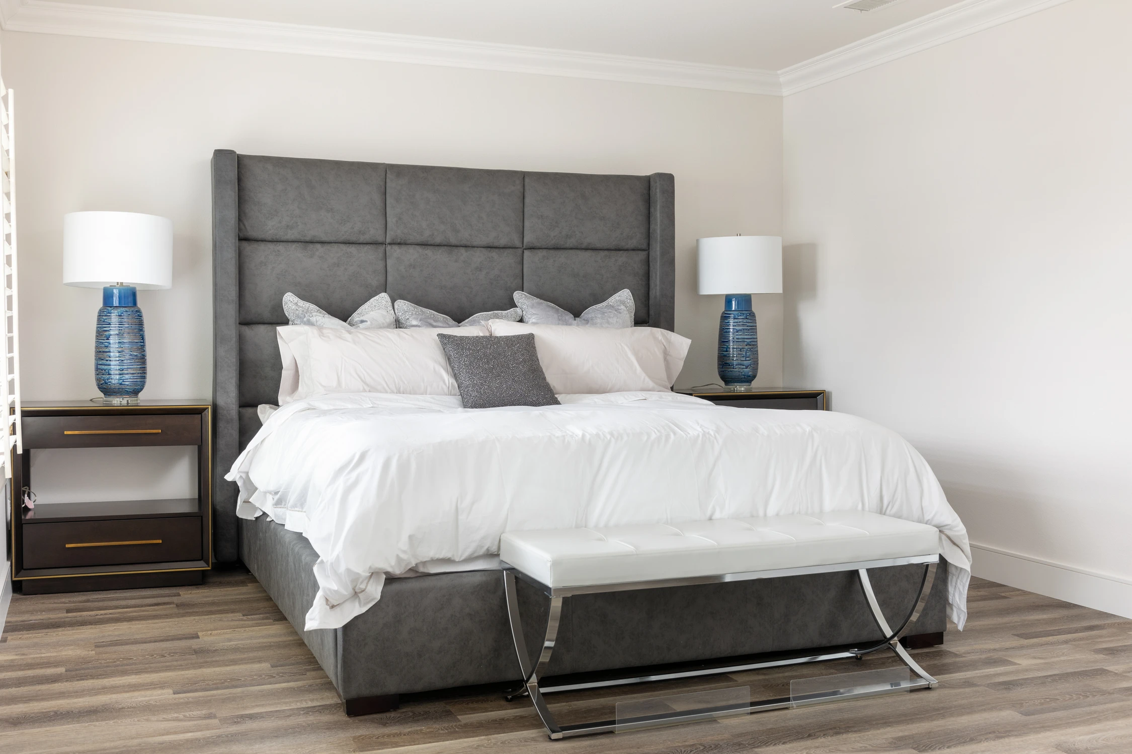 Bedroom with charcoal paneled headboard and white upholstered bench