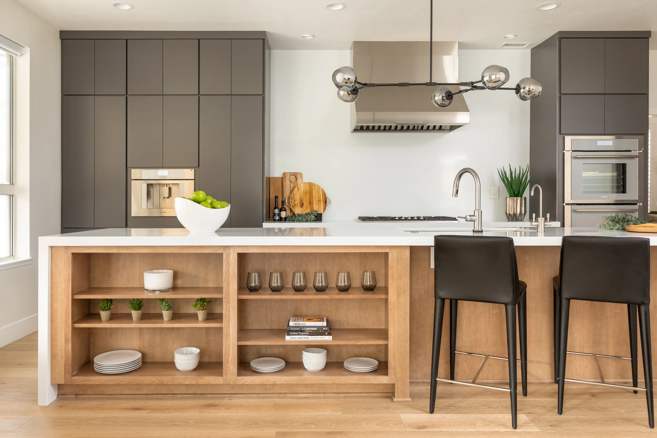 Kitchen with dark gray cabinets, white counter, and open island shelves