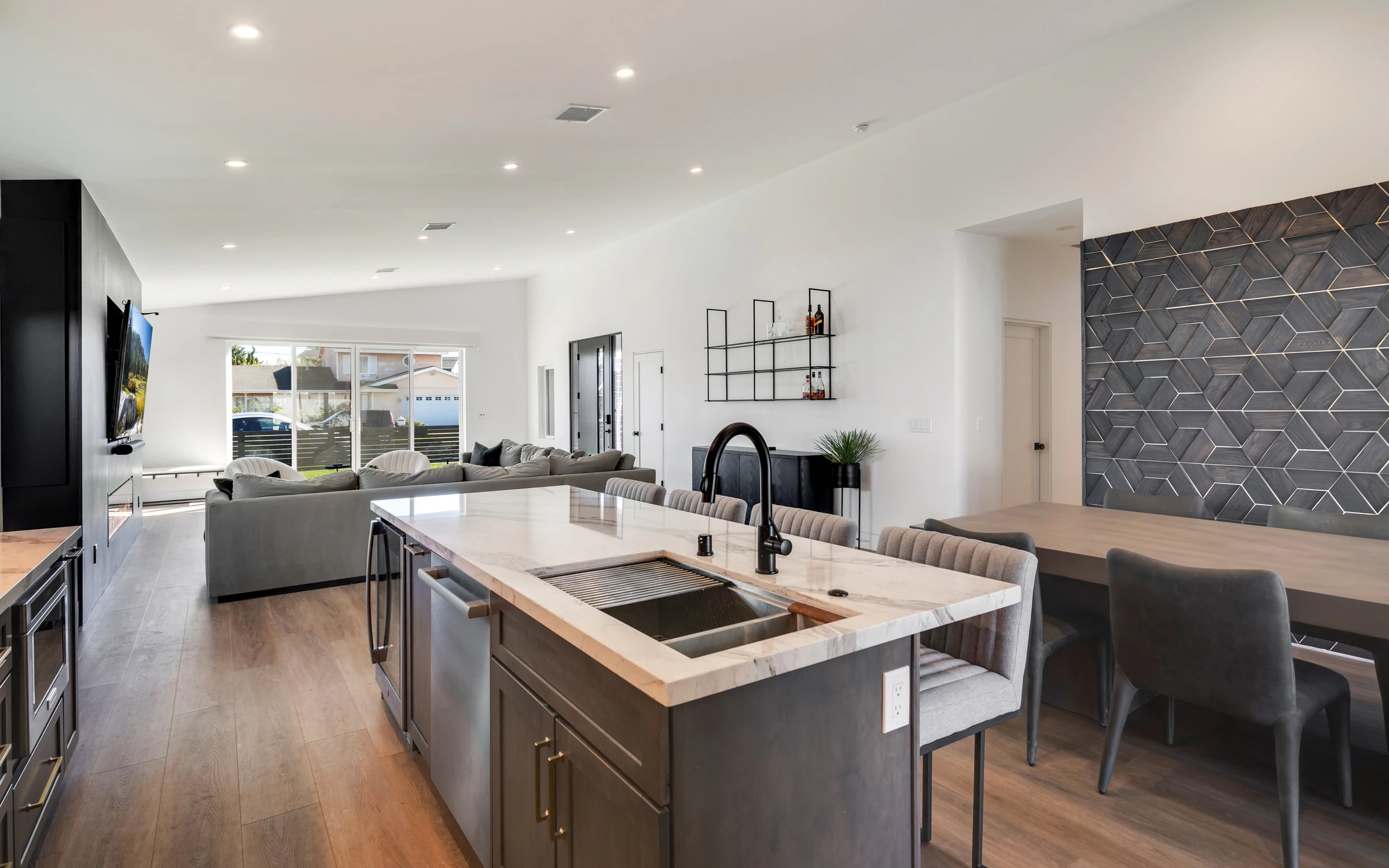 Kitchen island with black sink beside dining wall and living room
