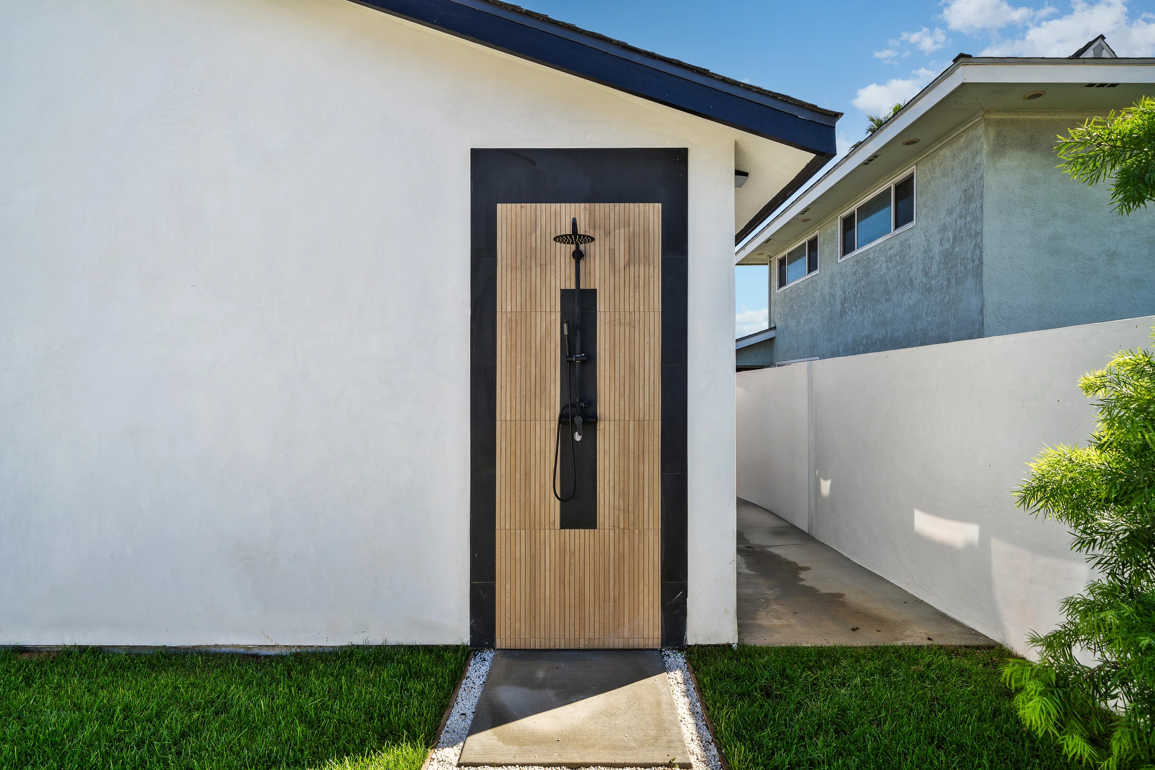 Outdoor shower with wood tile surround and black fixtures
