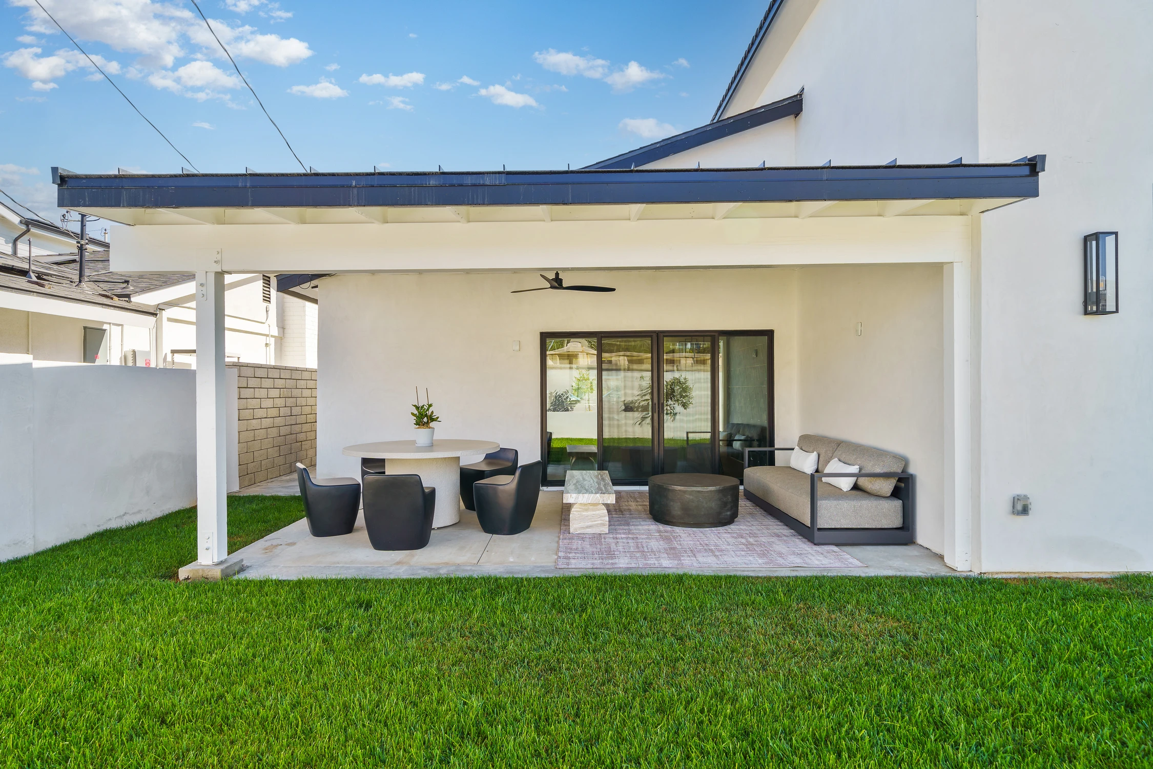 Covered backyard patio with outdoor dining and lounge seating