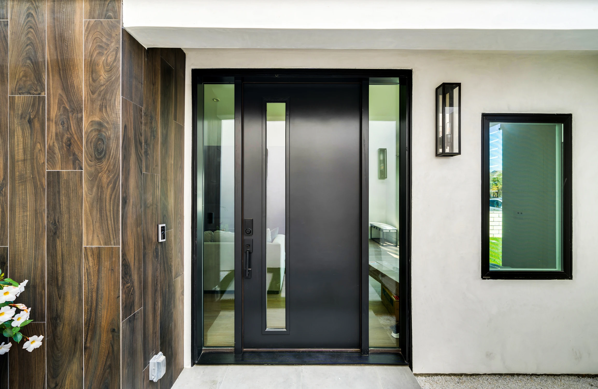 Modern black front door with sidelights and wood cladding