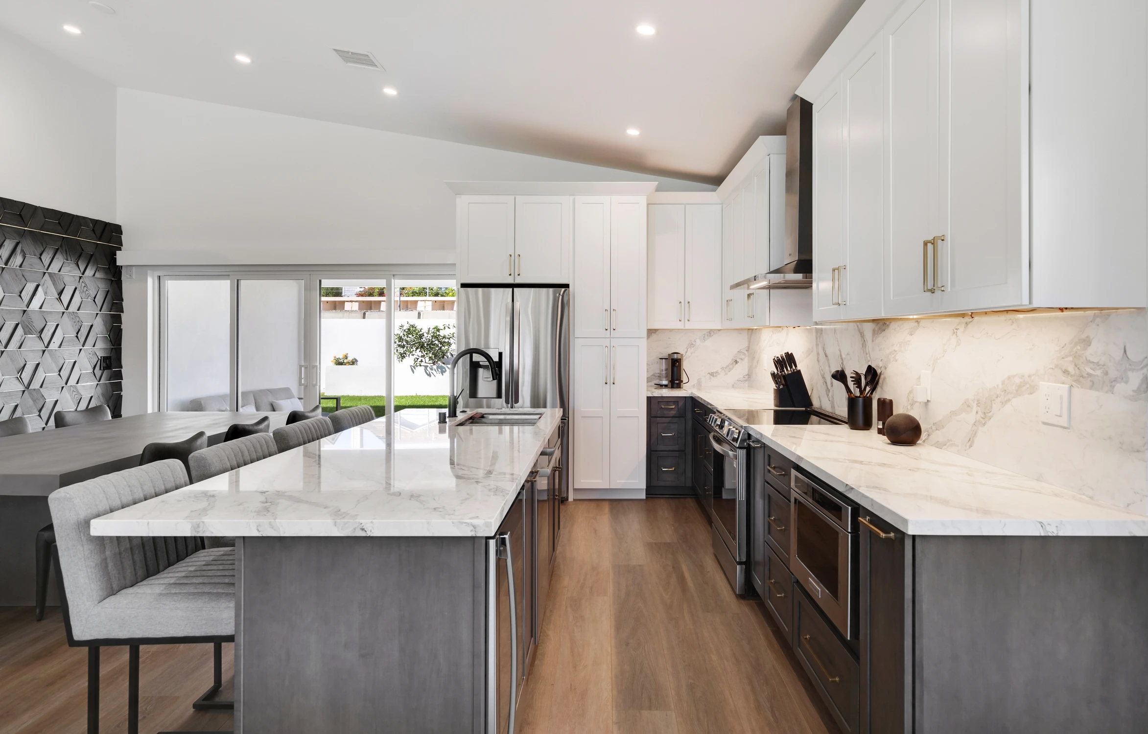 Kitchen and dining area with marble island and dimensional wood wall