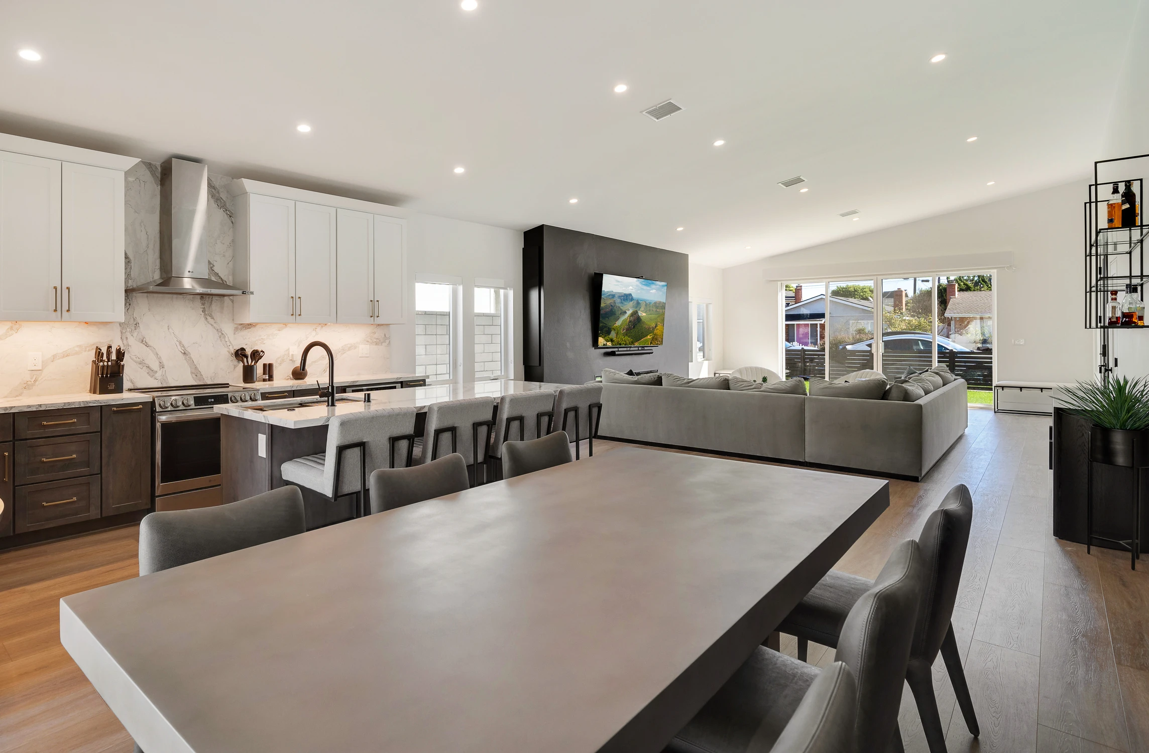 Open kitchen, dining area, and living room with black media wall
