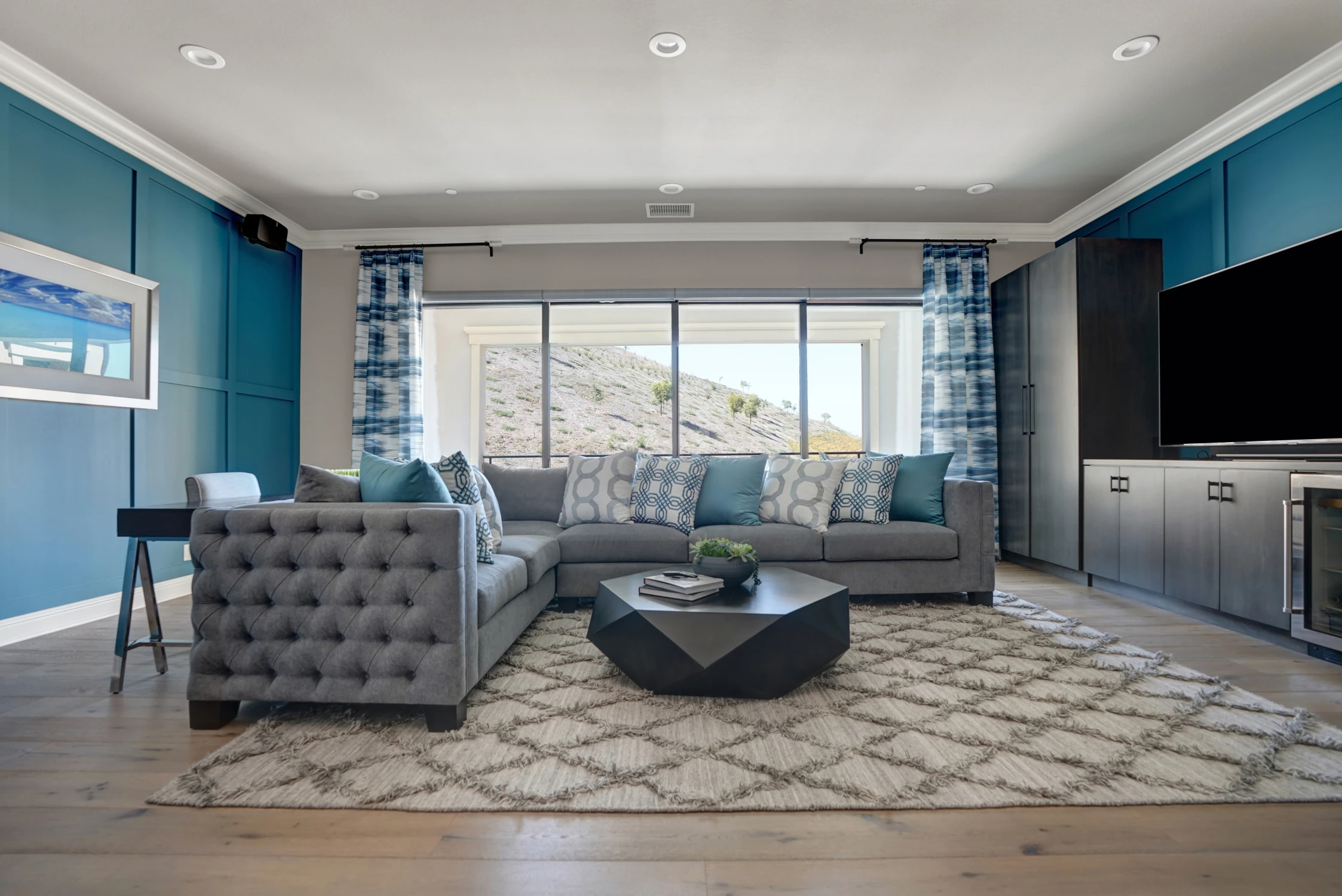 Blue living room with gray seating and large sliding glass doors