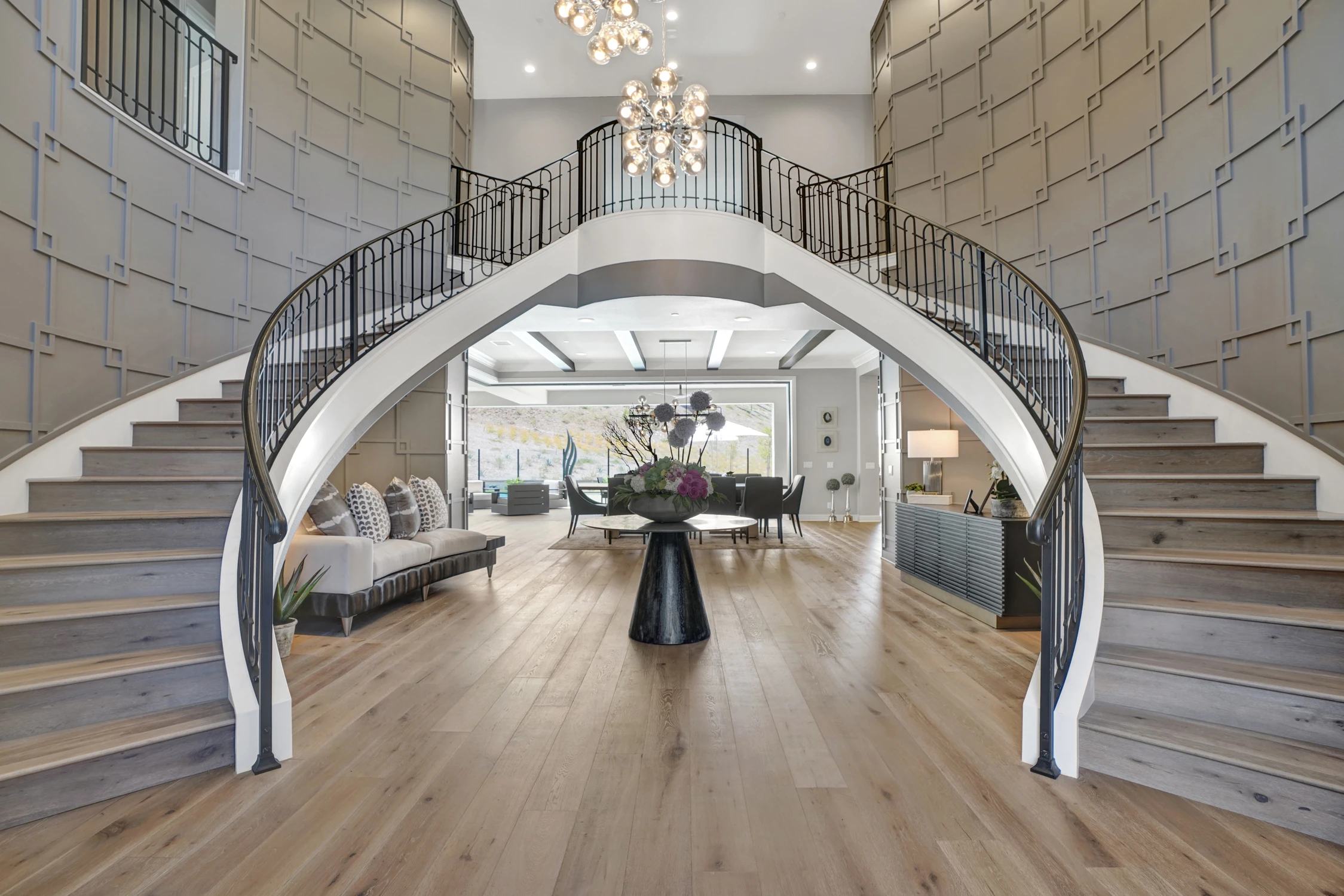 Grand foyer with curved staircases and chandelier