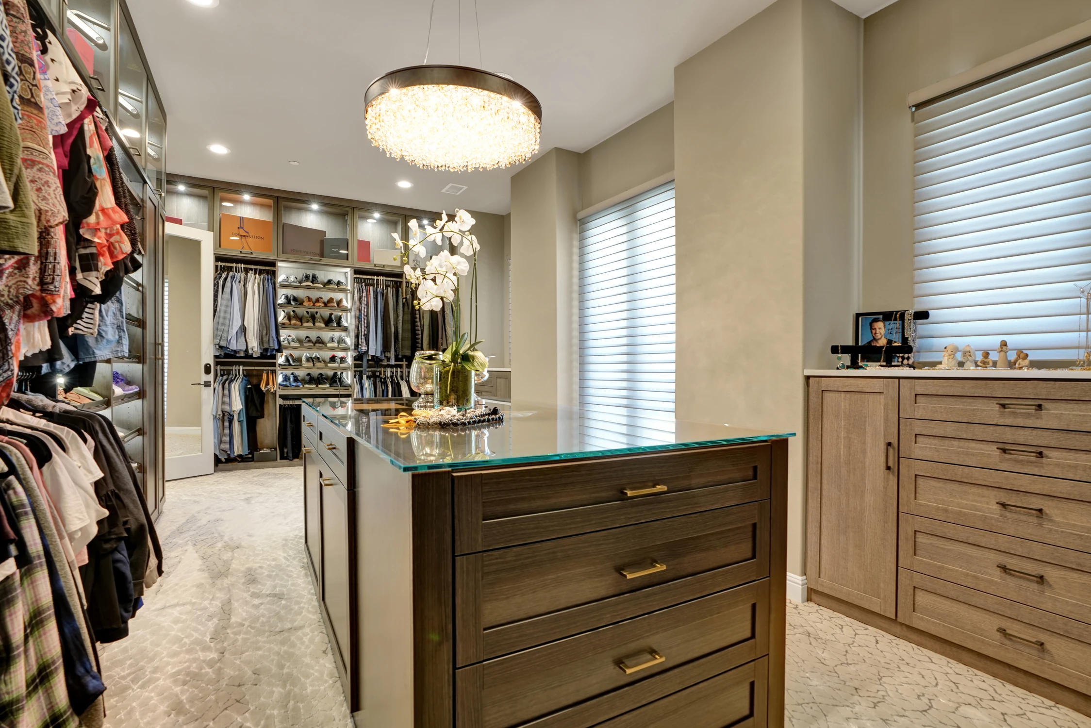 Walk-in closet with dark cabinetry, central island, and clothing storage