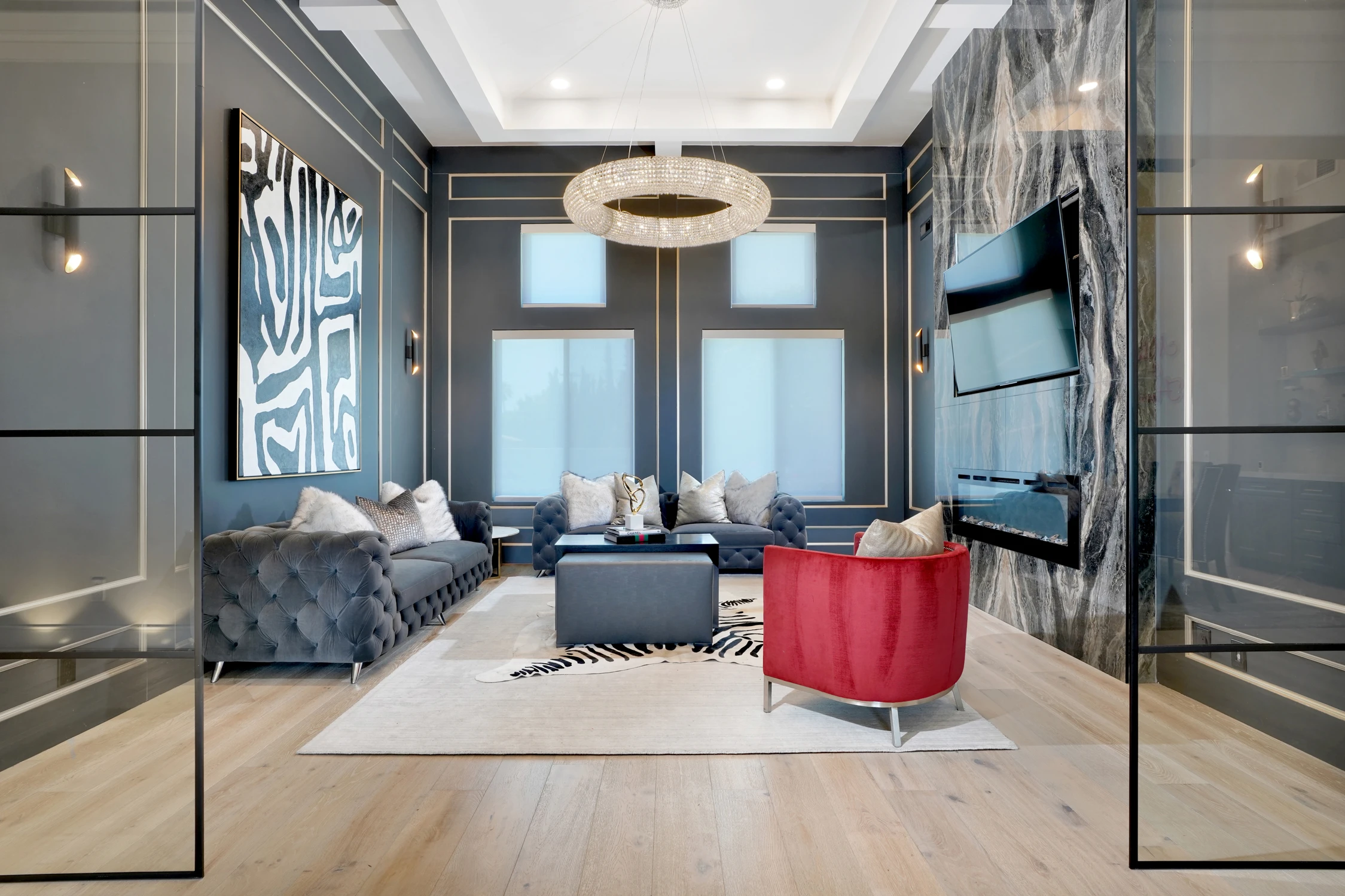Living room with dark paneled walls, patterned rug, and red accent chair