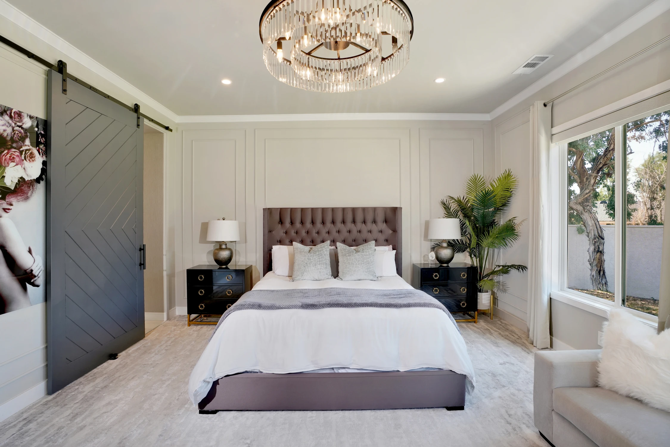 Bedroom with upholstered bed, dark sliding doors, and garden windows