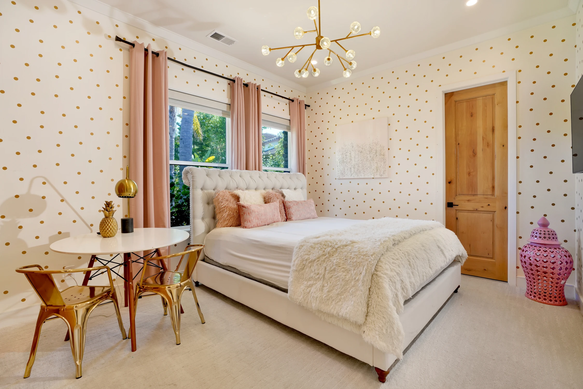 Bedroom with floral wallpaper, white bedding, and pale wood door