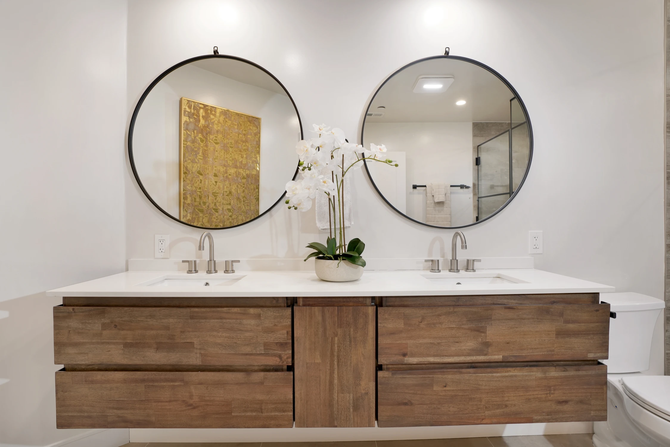 Bathroom double vanity with round mirrors and natural wood drawers