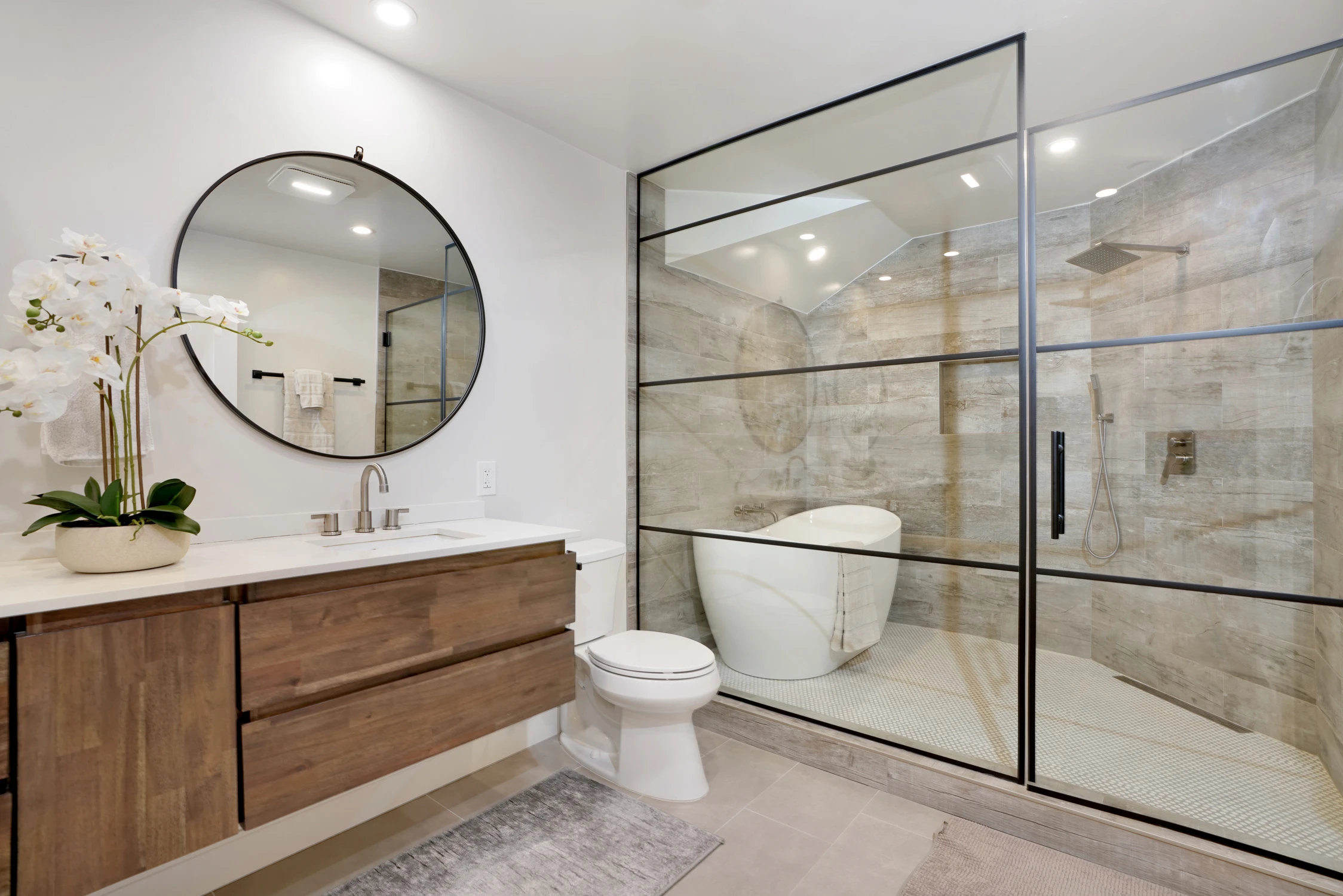 Bathroom vanity with wood drawers, glass shower, and white toilet