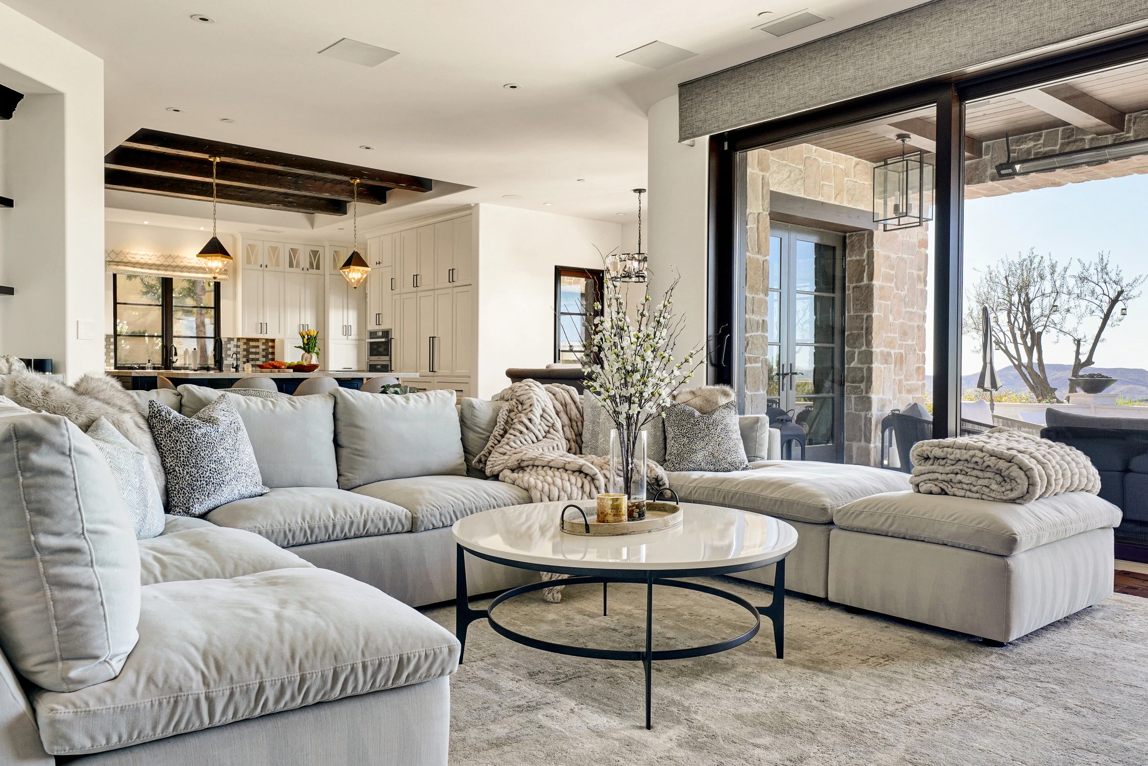 Living room with white sectional beside open kitchen