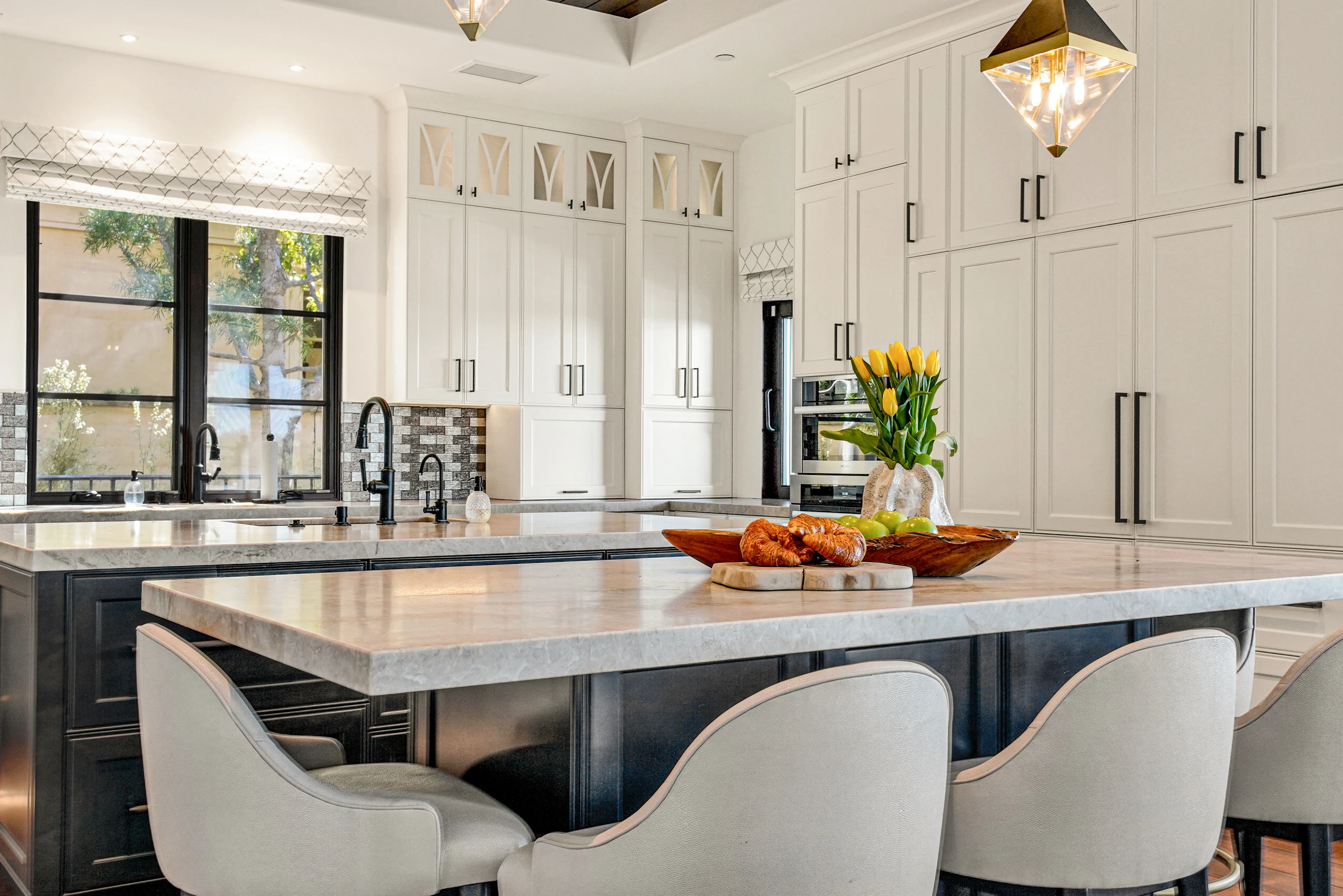 Kitchen island with white stools and black faucet