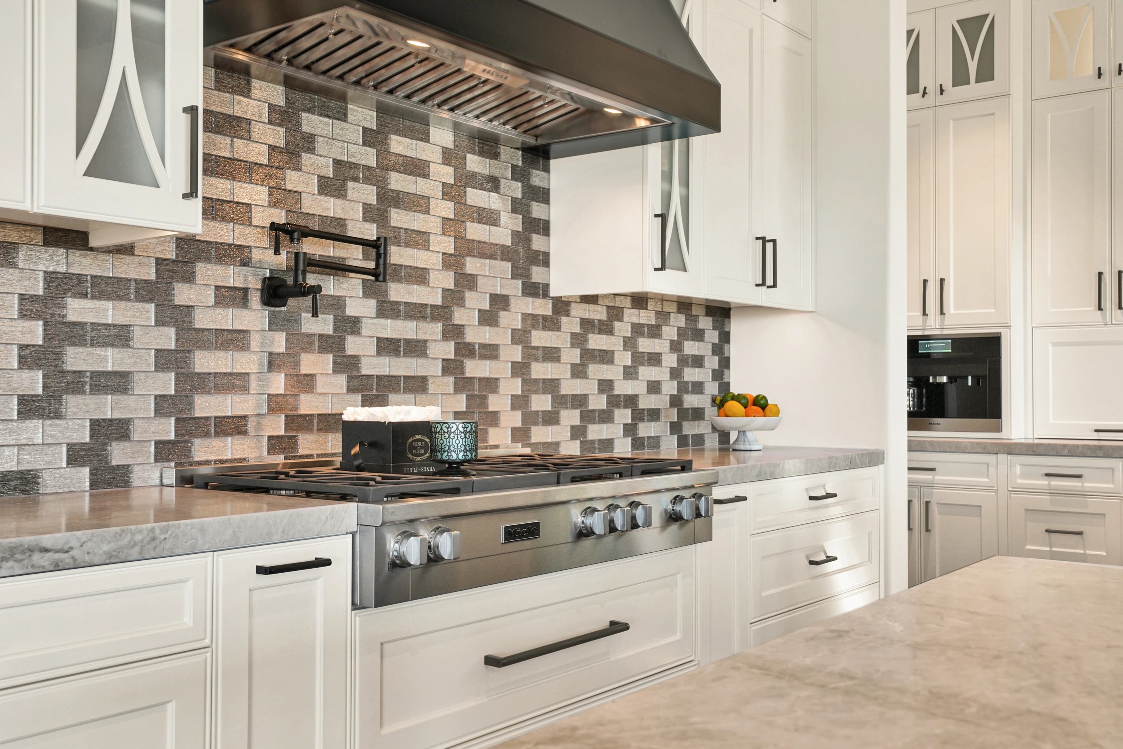 White kitchen with mosaic backsplash, range, and wood ceiling beams