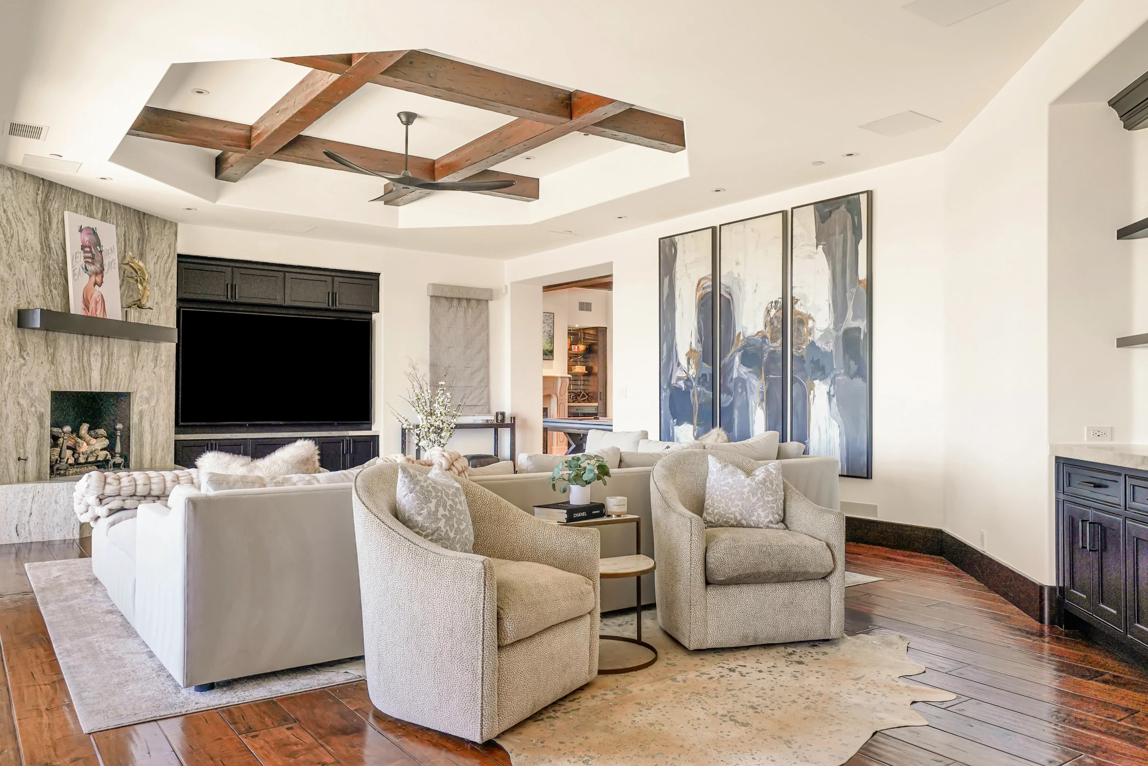 Living room with white seating, dark built-ins, and wood beams