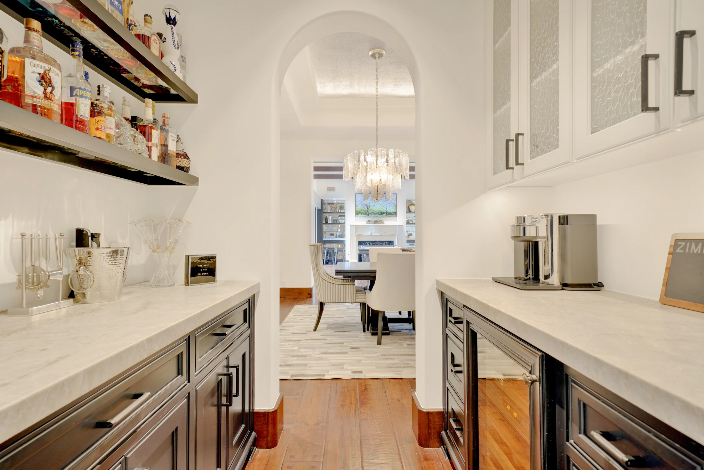 Butler's pantry with open bottle shelves and white cabinetry
