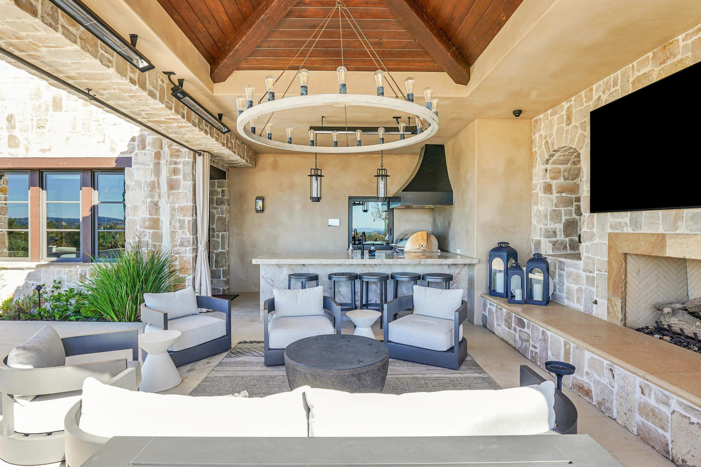Covered patio with outdoor kitchen, fireplace, and seating