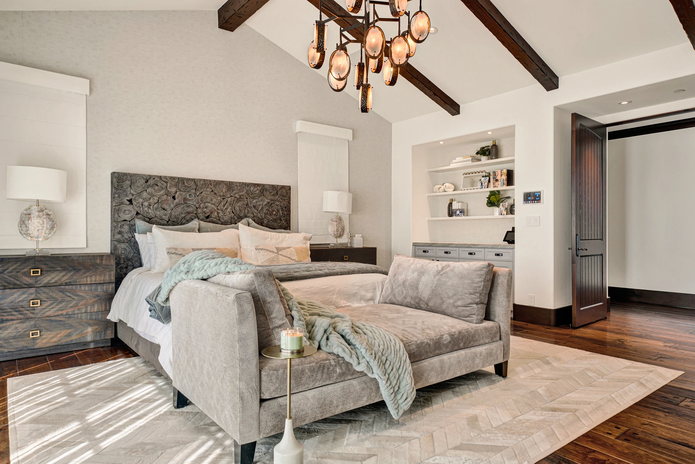 Primary bedroom seating area with gray sofas and wood beams