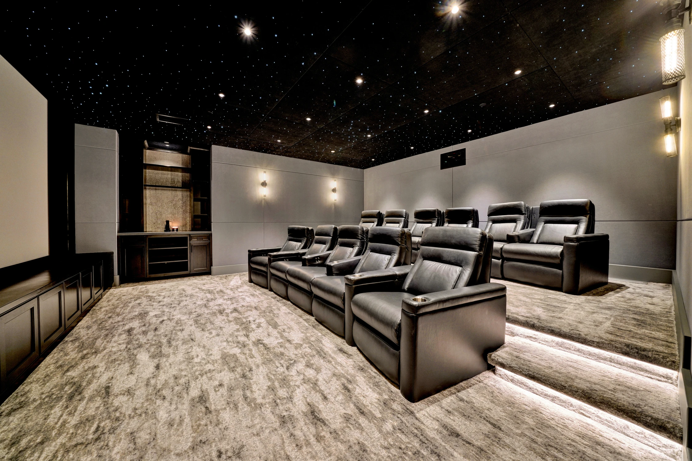 Home theater with black recliners and starry black ceiling