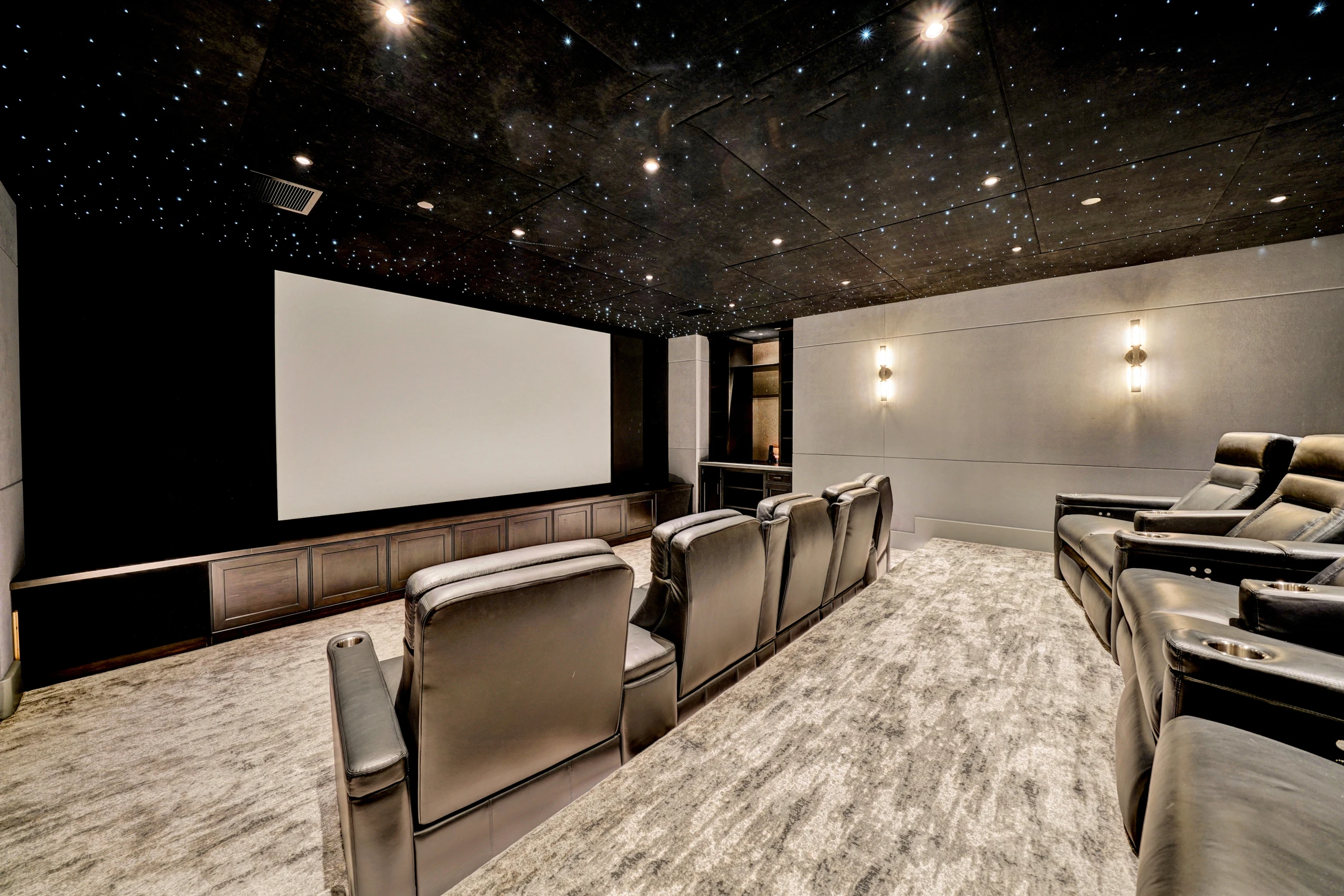 Home theater side view with tiered black recliner seating