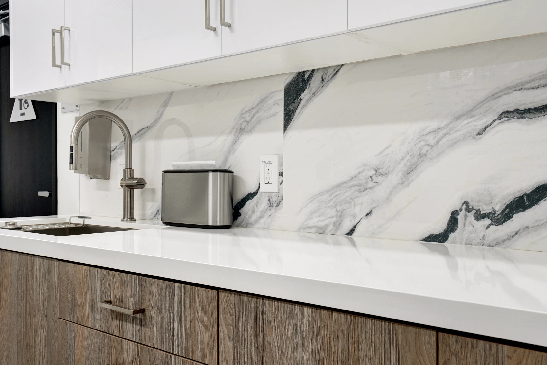 Close view of marble-look backsplash and stainless kitchen sink