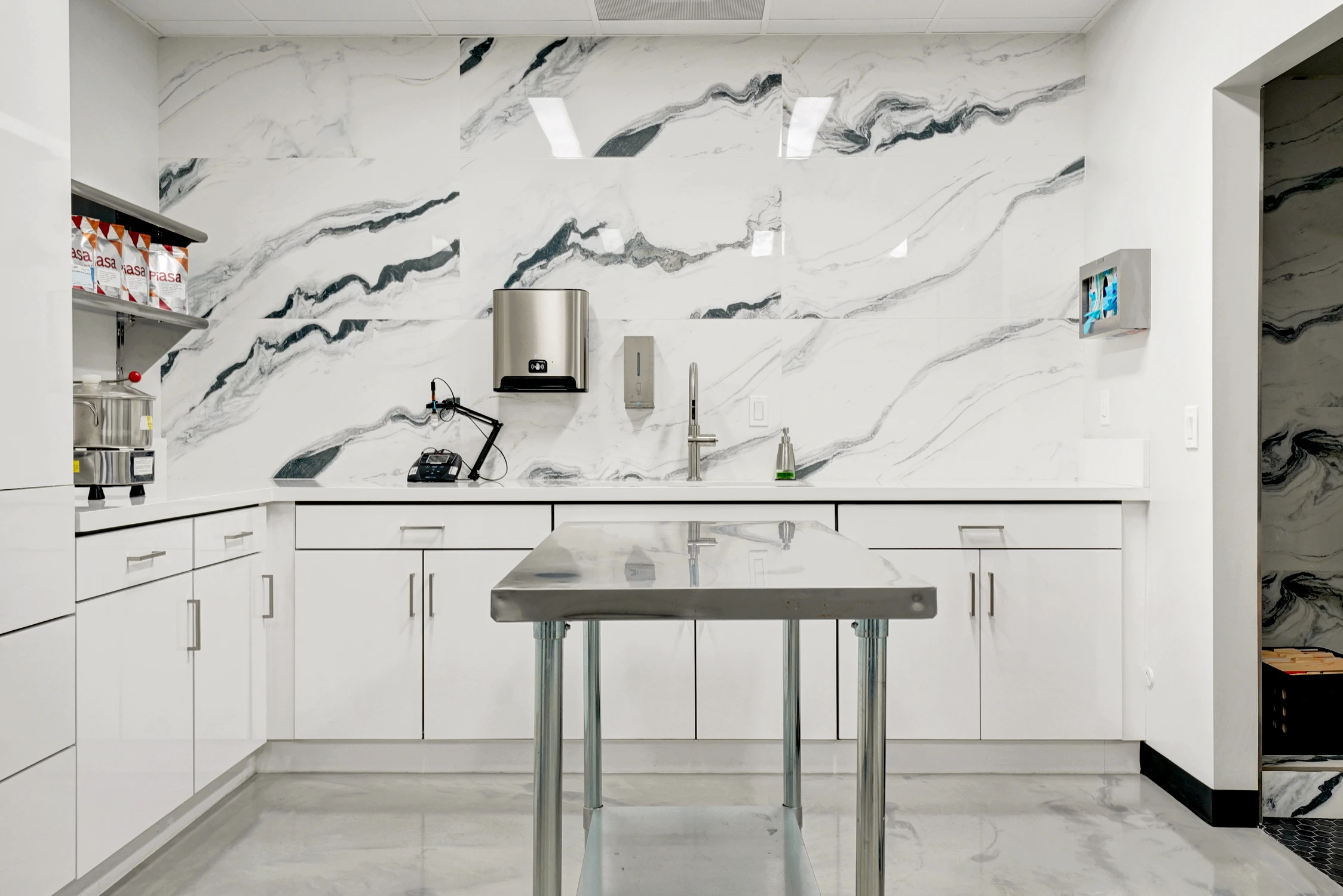Break room counter with marble-look backsplash and high stools