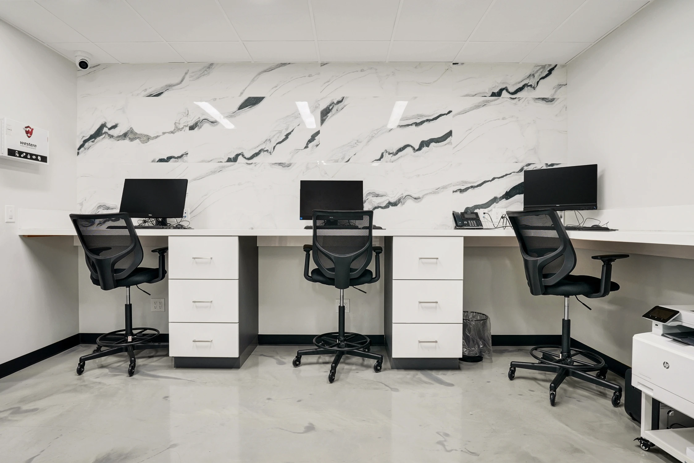 Workstation wall framed by bold black-and-white marble-look panels