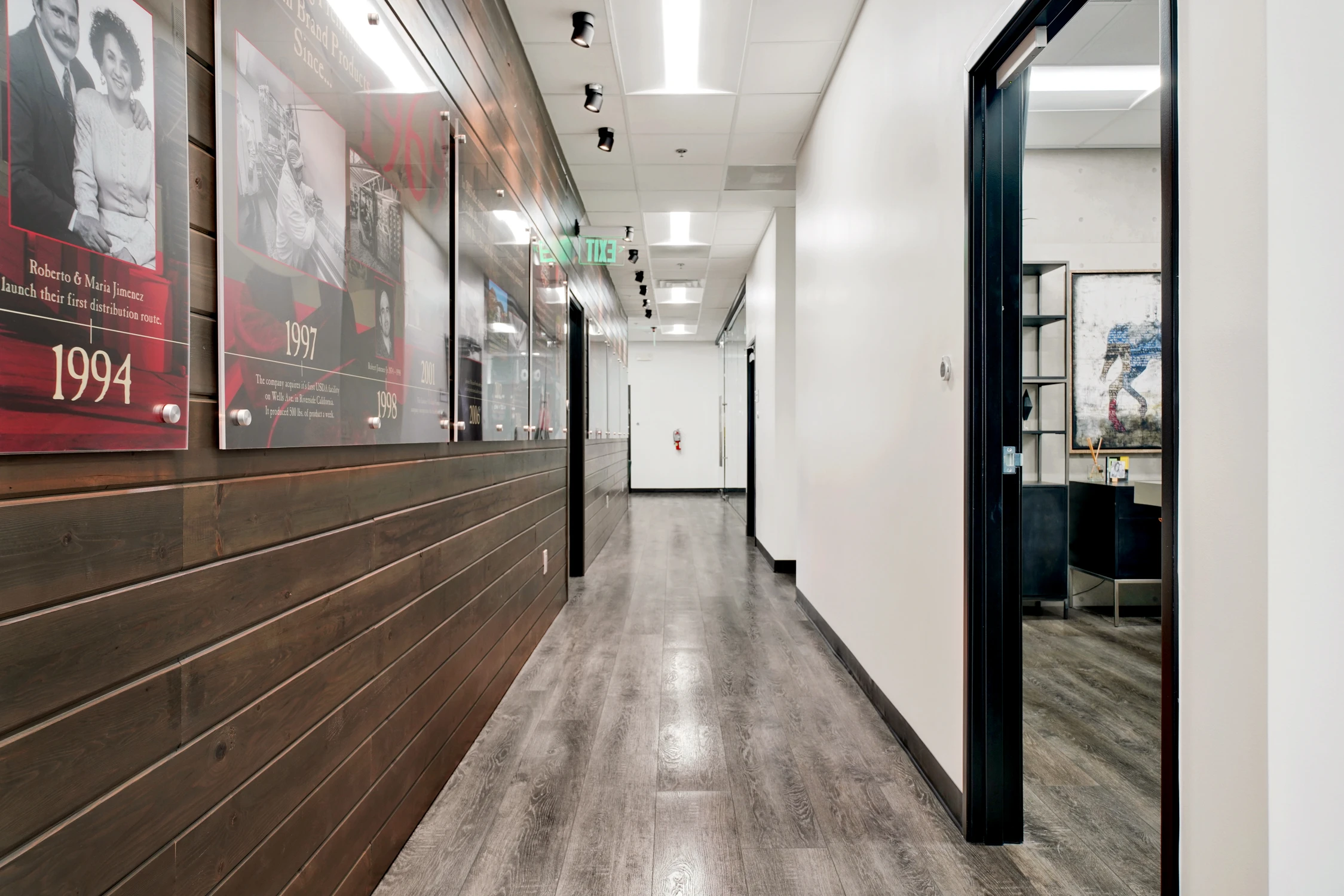 Commercial hallway with wood wall panels and framed company display