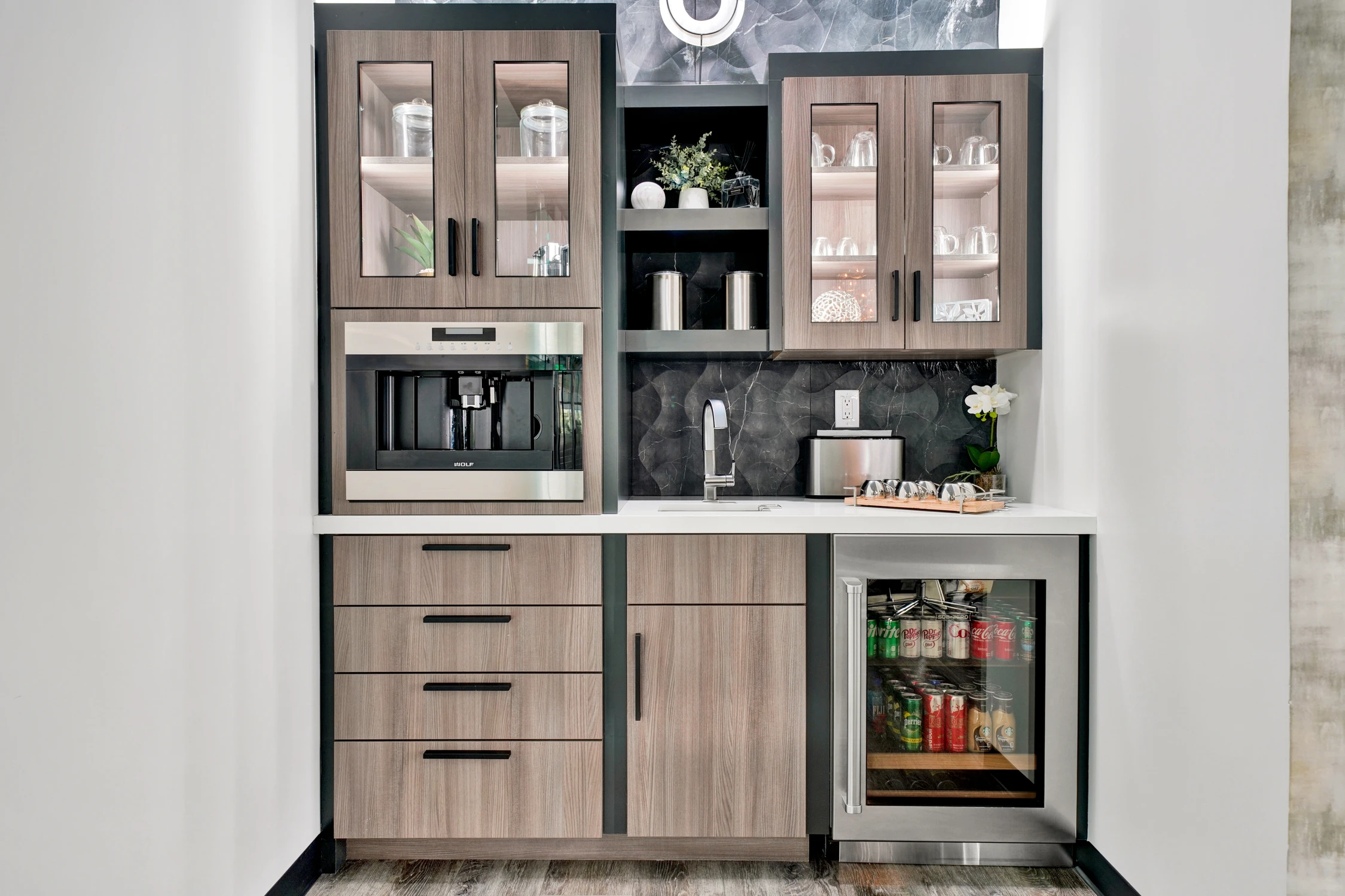 Built-in beverage cabinet with coffee maker, sink, and glass-front storage