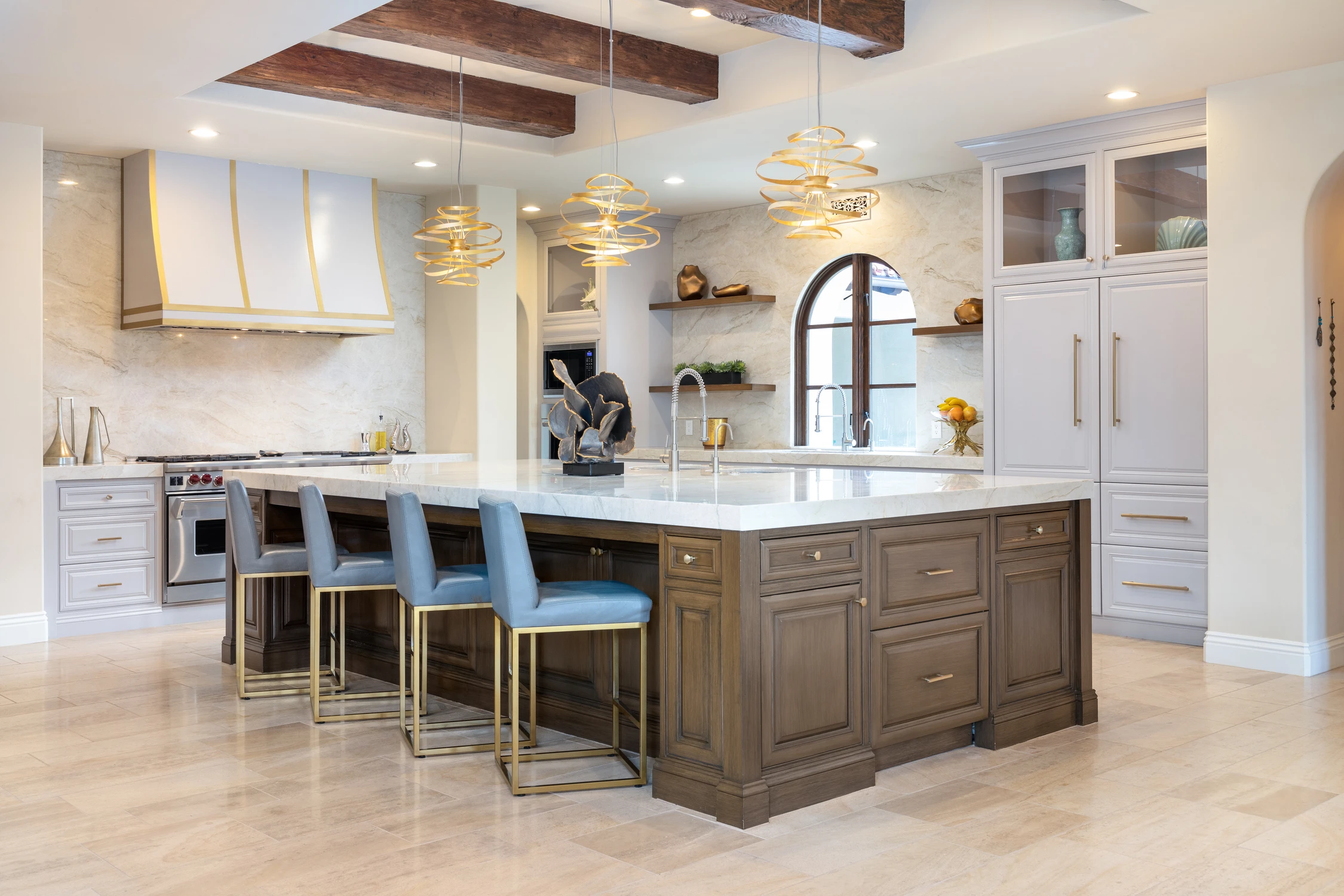 Kitchen with white island, warm wood cabinetry, and blue stools