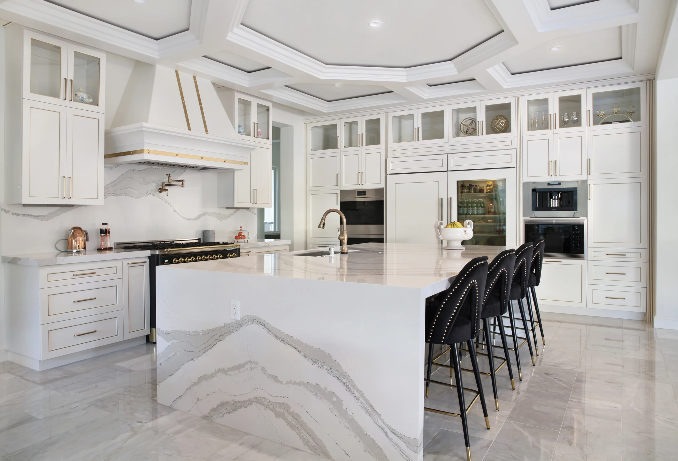 White kitchen with black stools and detailed ceiling panels