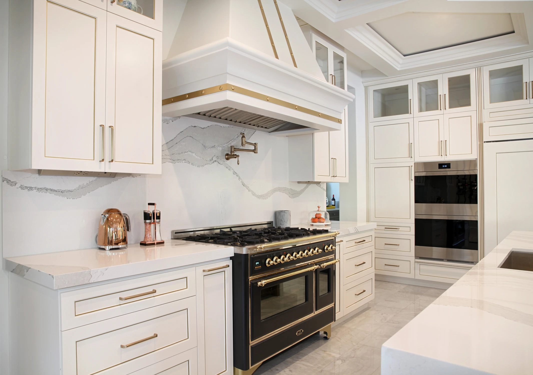 White kitchen range wall with black oven and marble-look backsplash