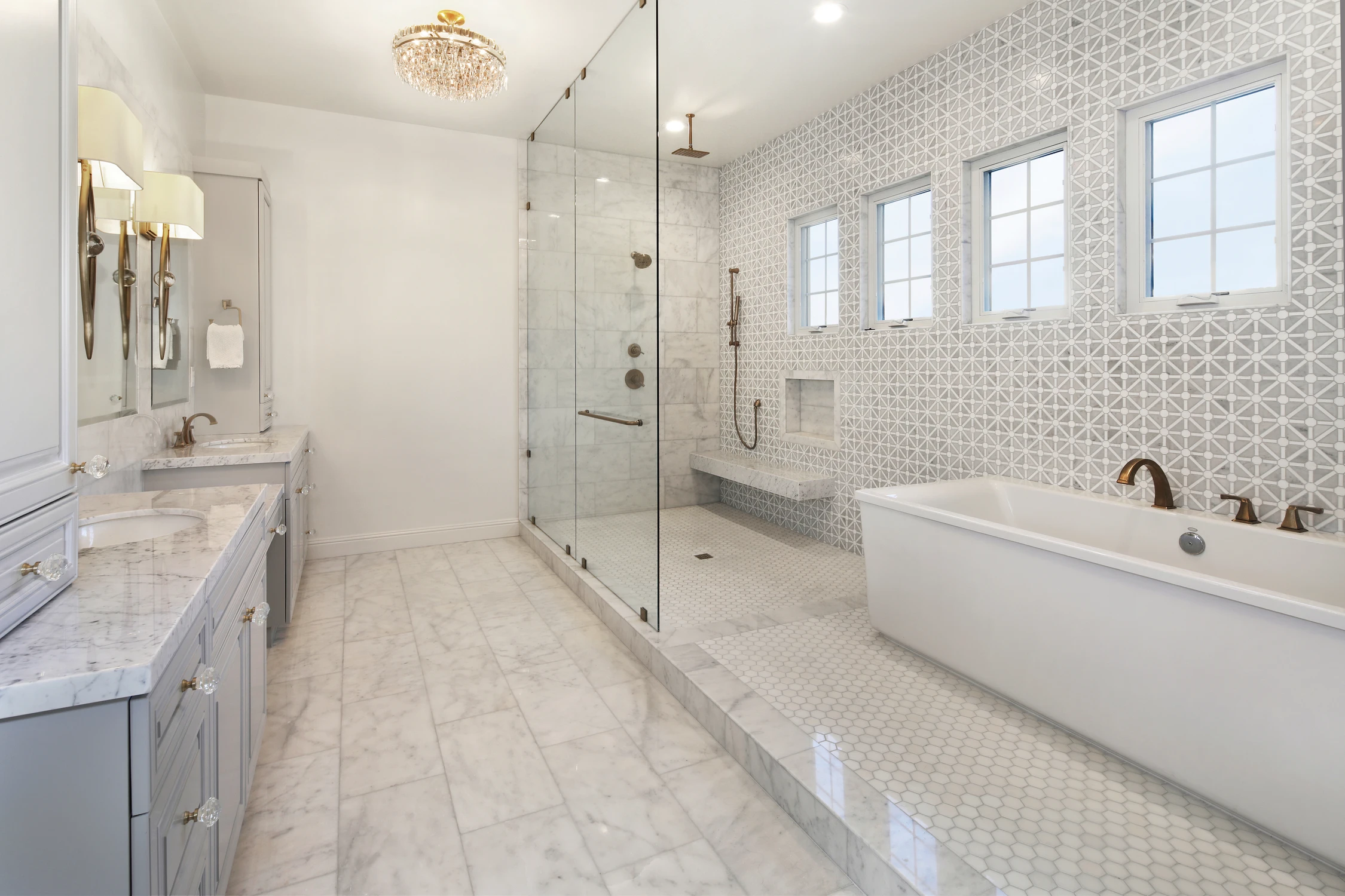 Master bathroom with freestanding tub, glass shower, and pale tile