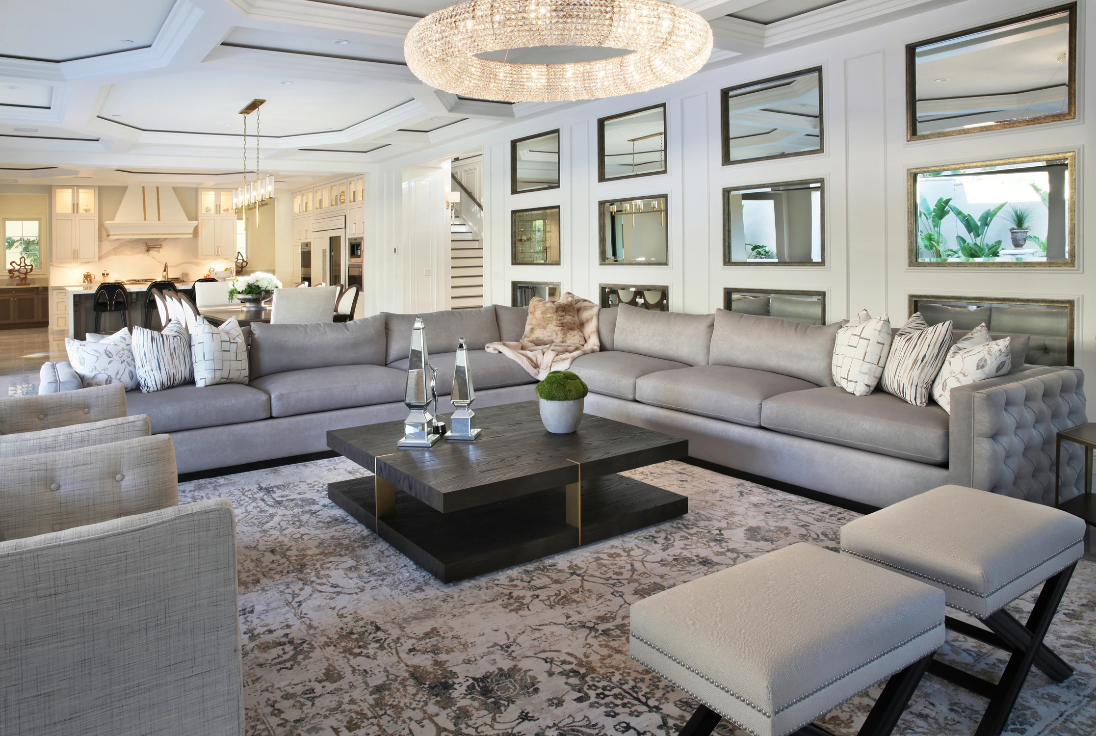Living room with gray seating, framed art wall, and open kitchen