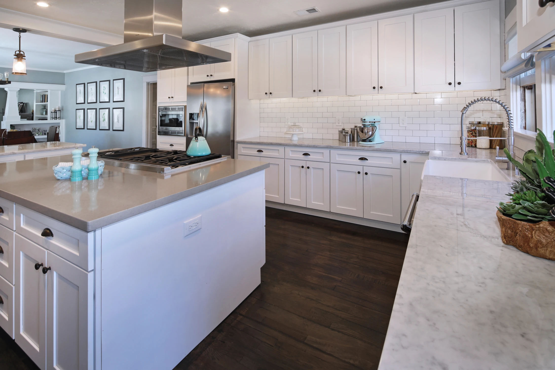 Kitchen island and white cabinetry against dark wood flooring