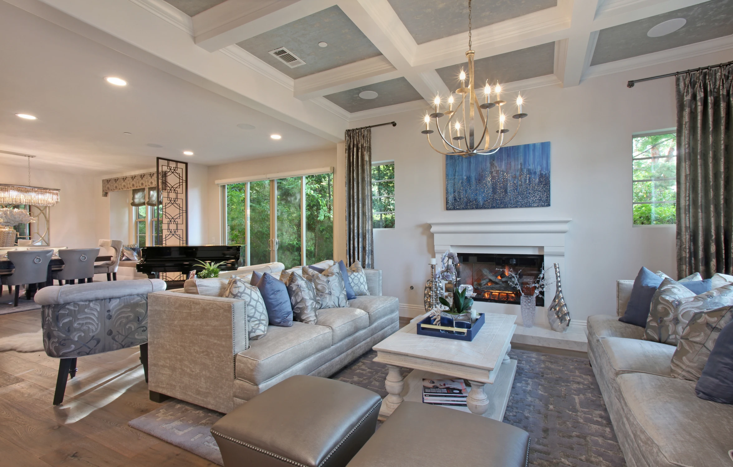 Formal living room with pale sofas, arched windows, and dark drapery