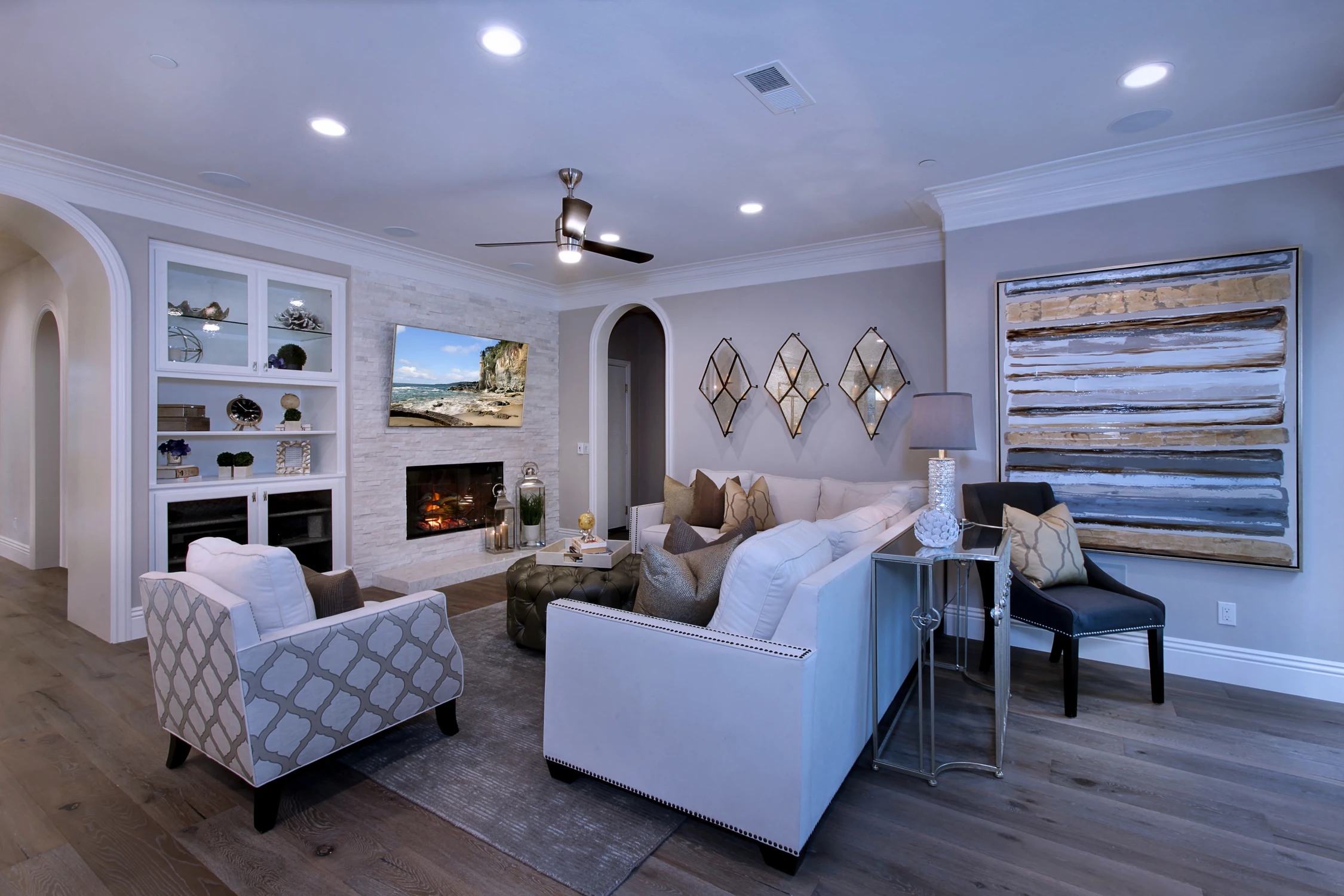 Family room with white built-ins, fireplace, and pale lounge chairs
