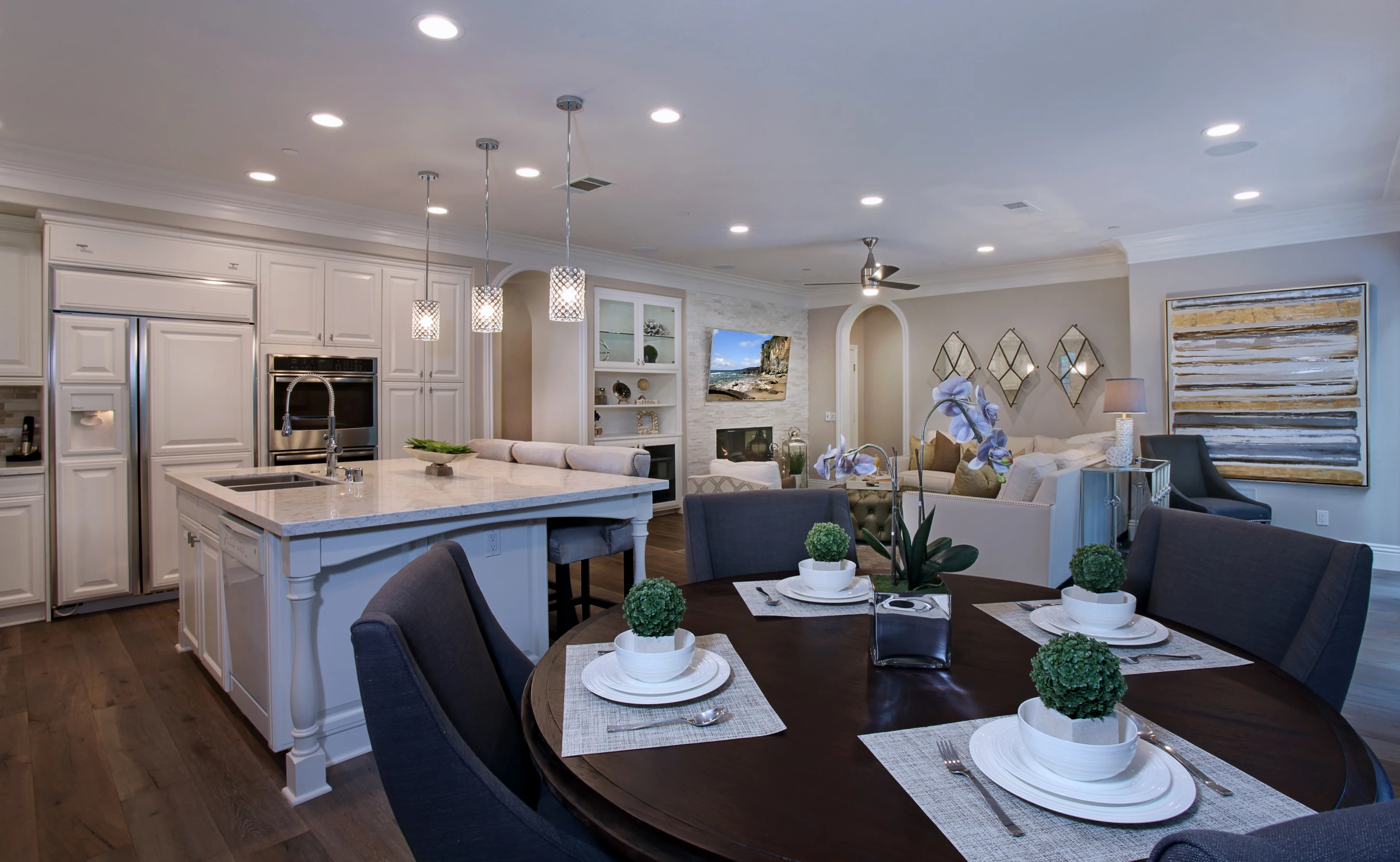 Open kitchen and dining area with white island and dark wood flooring