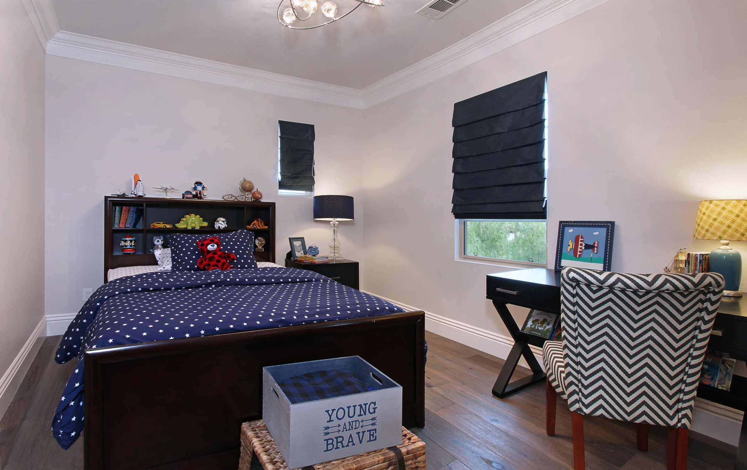 Bedroom with dark wood bed, navy bedding, and chevron accent chair