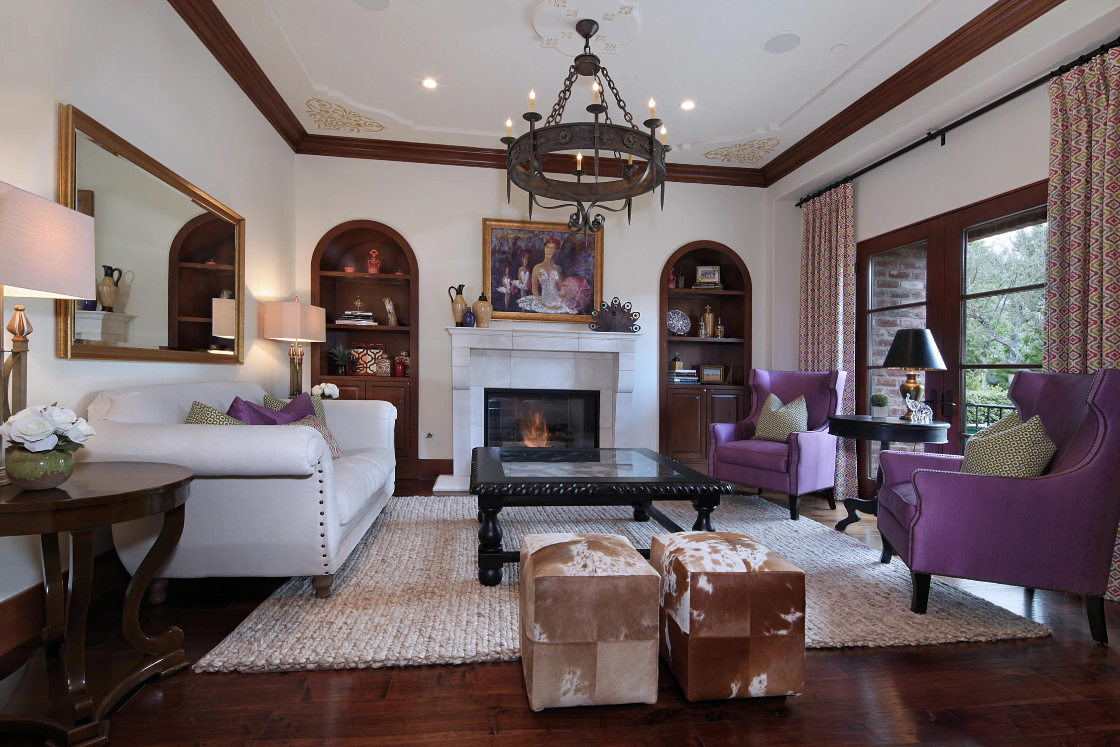 Living room with arched bookcases, fireplace, and dark wood beams