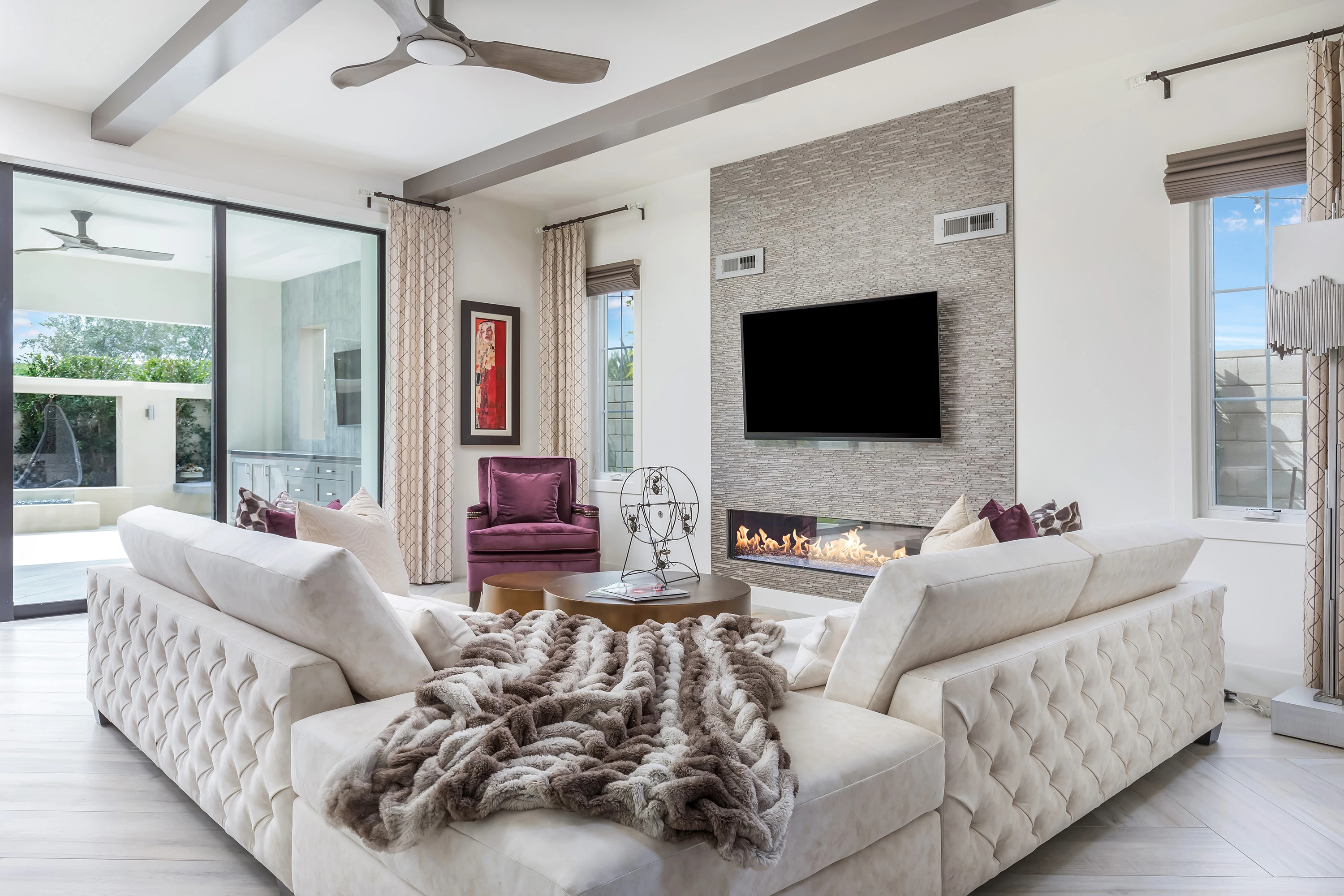 White tufted sectional surrounding a modern fireplace