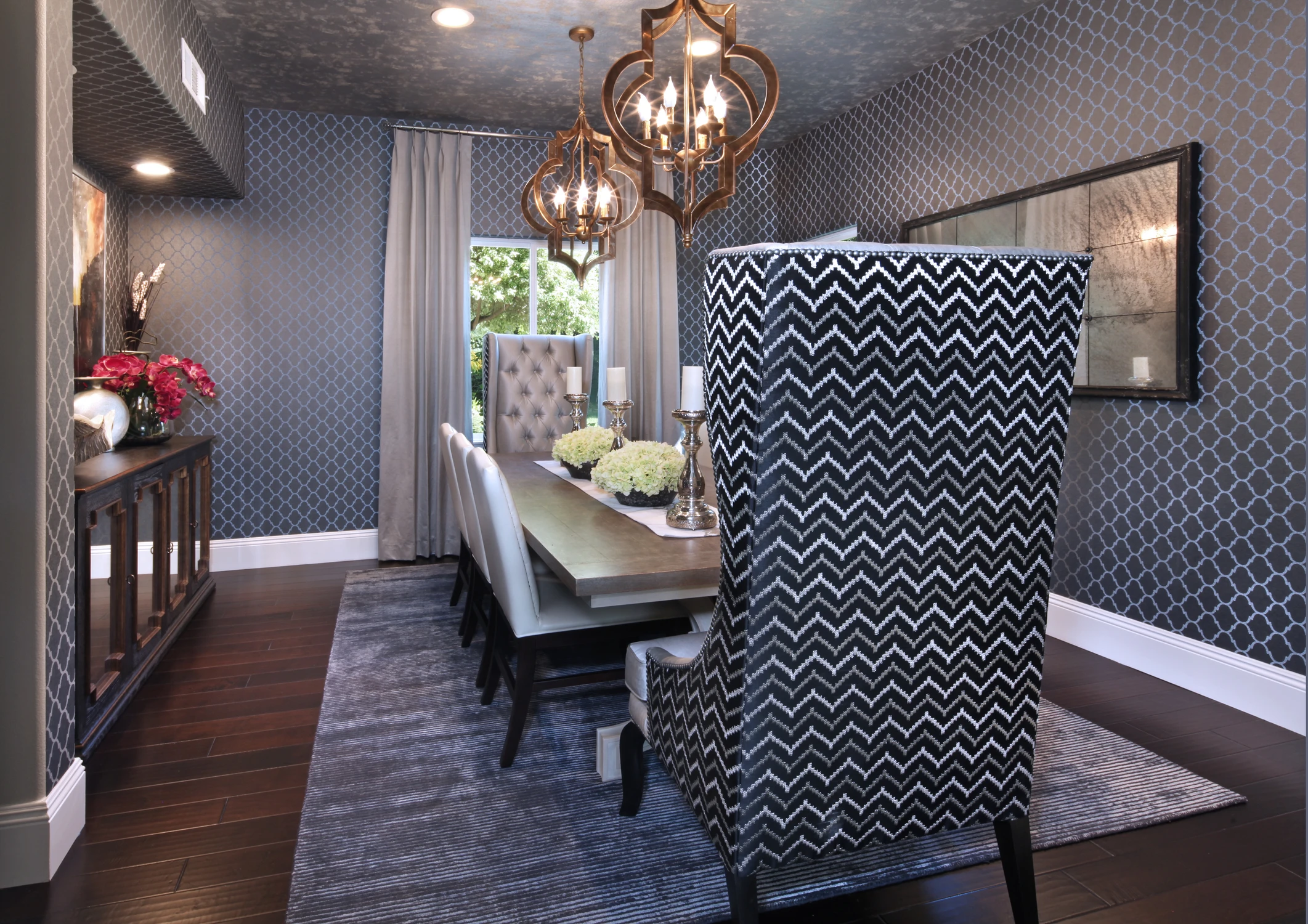 Formal dining room with dark patterned walls and globe pendants
