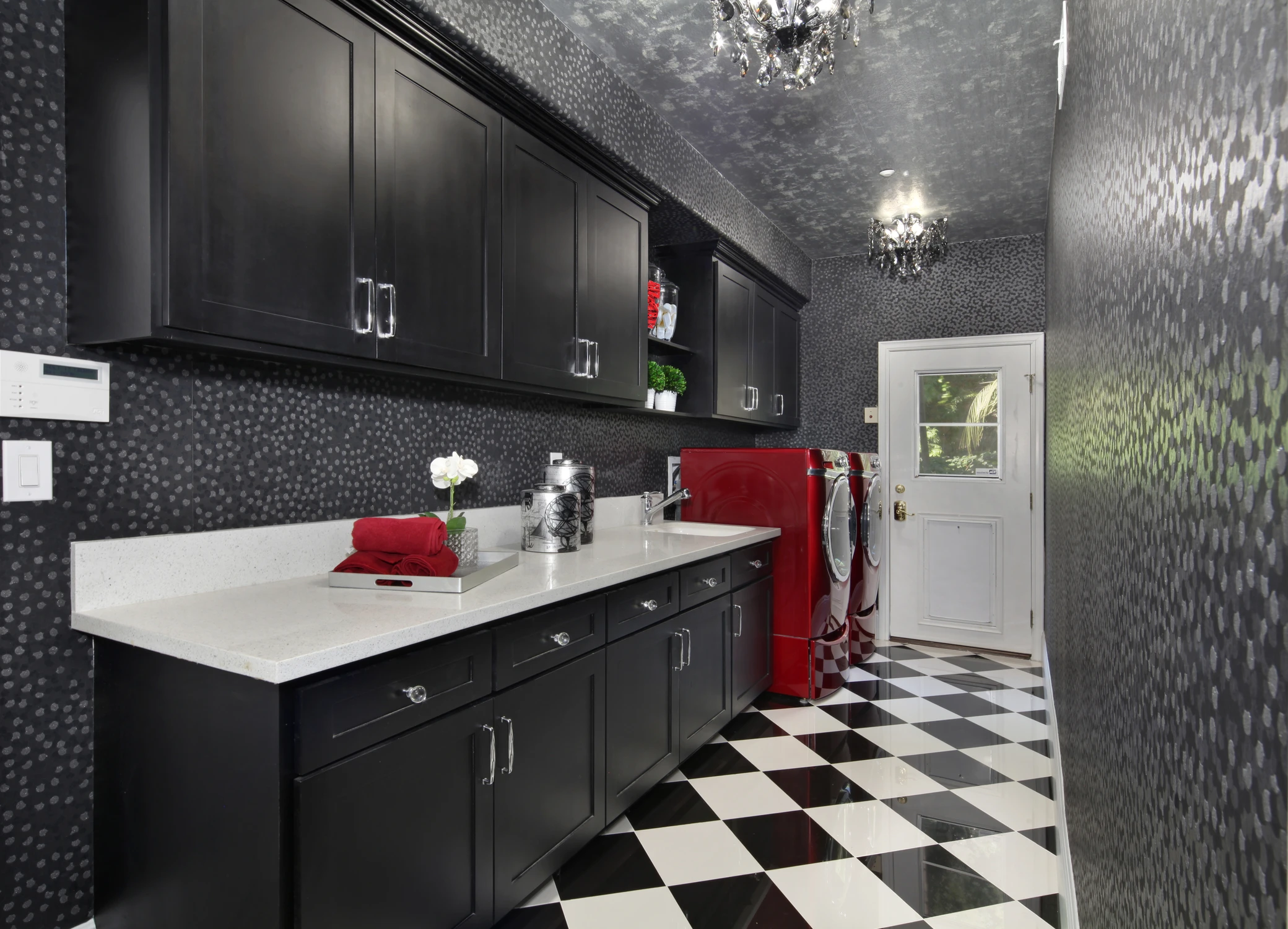 Laundry room with black cabinets and checkerboard floor
